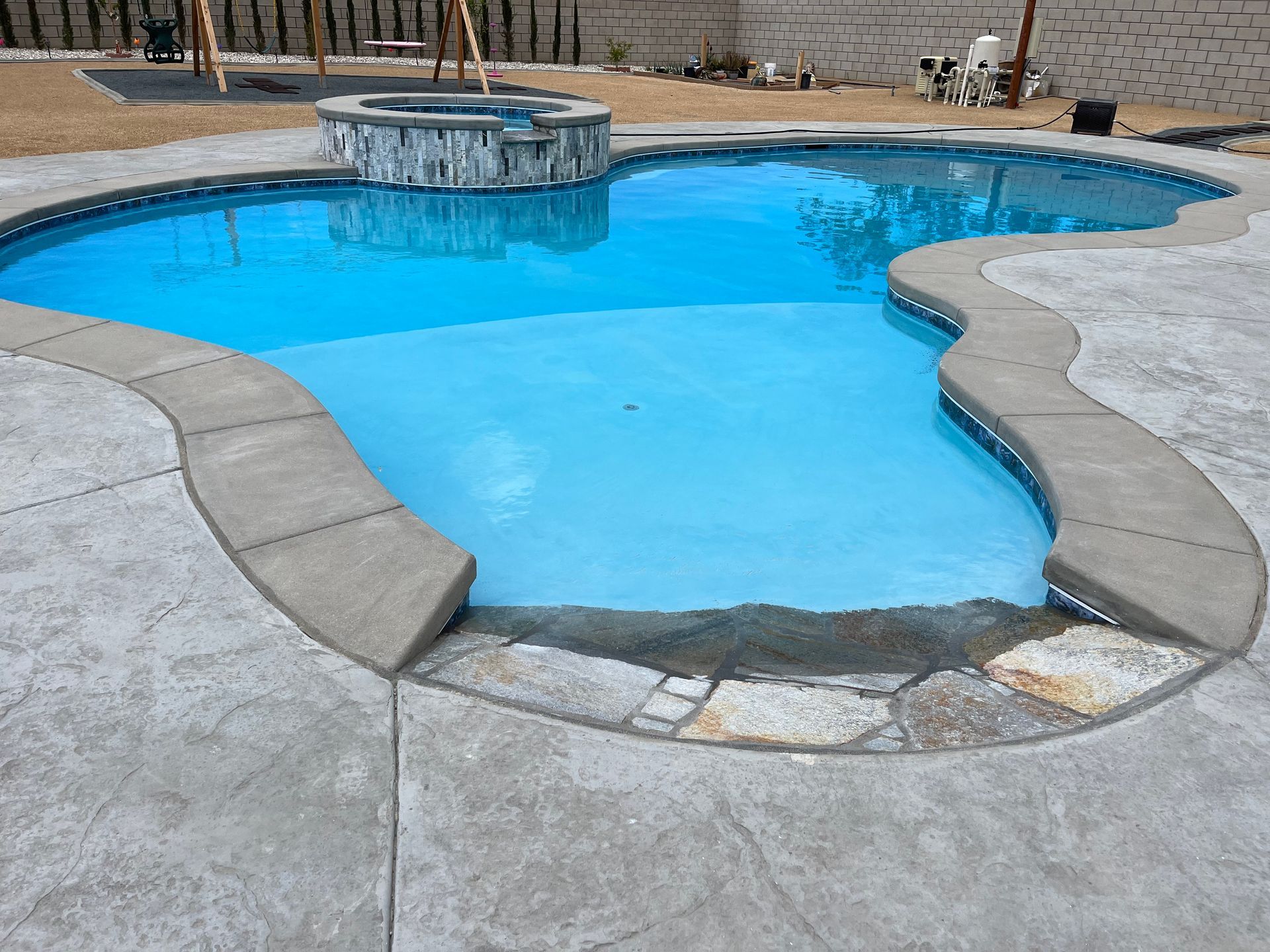 A large swimming pool with a hot tub in the middle