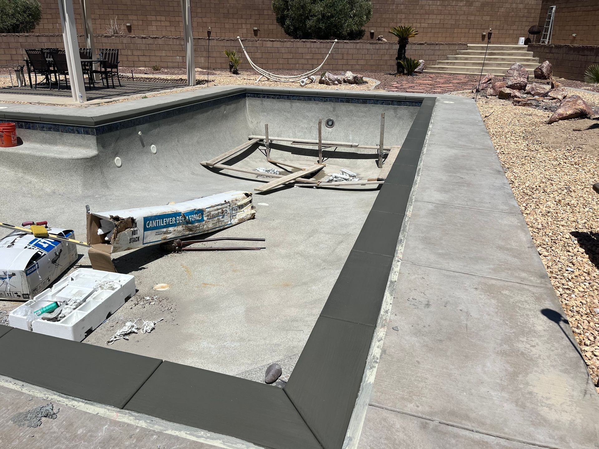 A swimming pool is being built in a backyard.