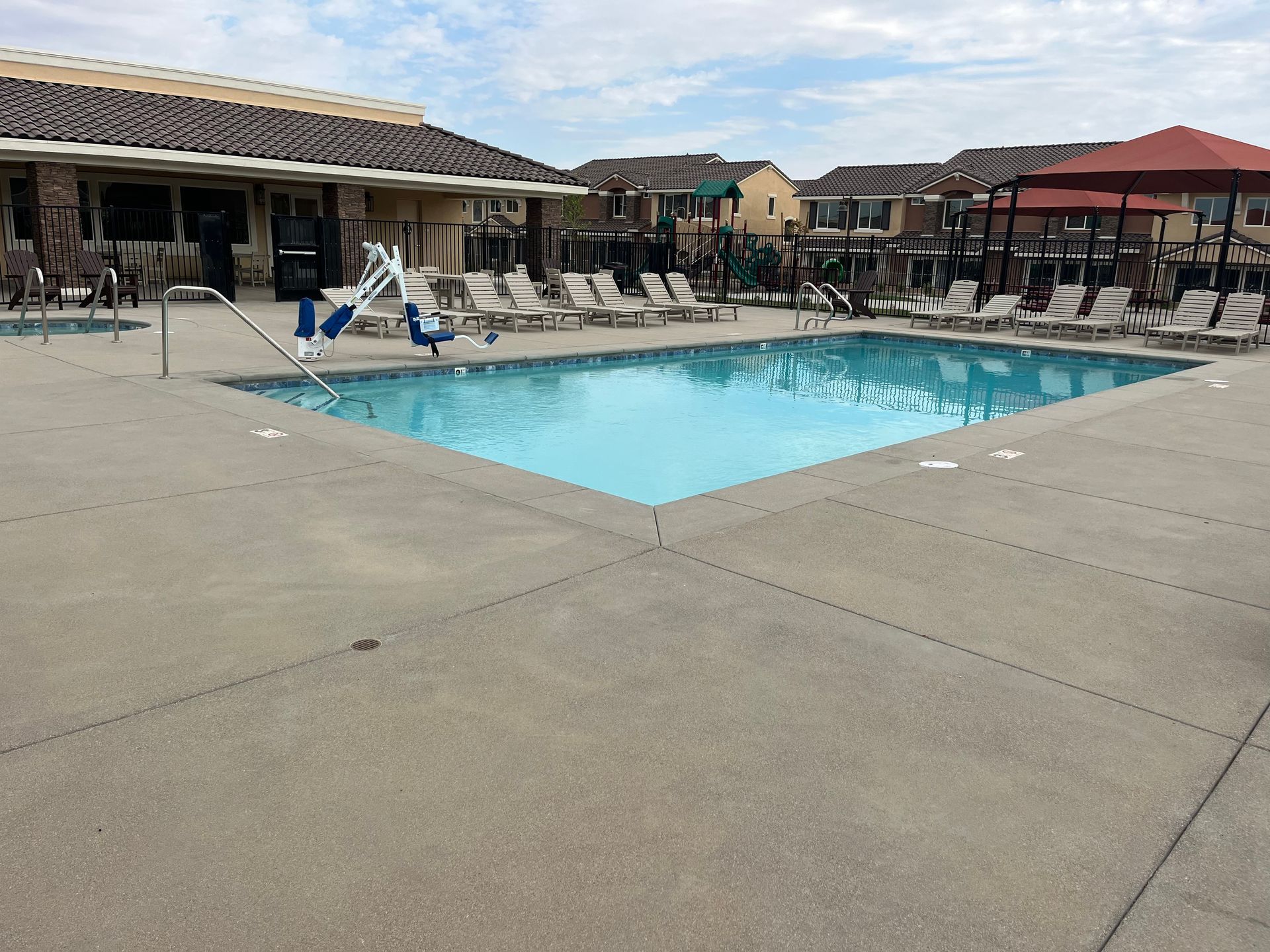 A large swimming pool surrounded by chairs and umbrellas