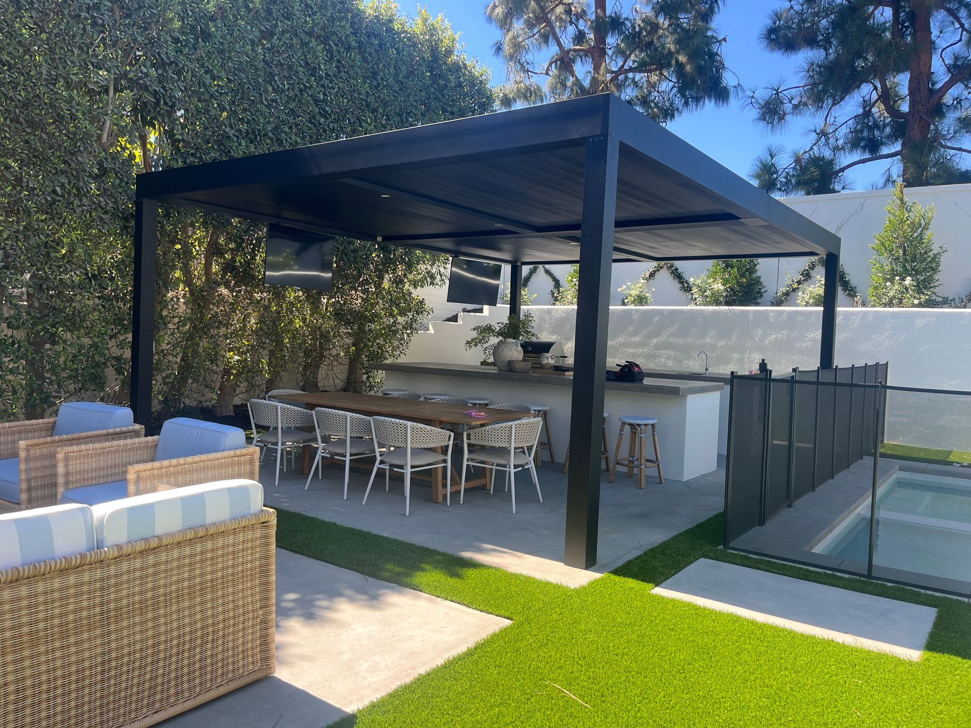 A patio with a table and chairs under a pergola.
