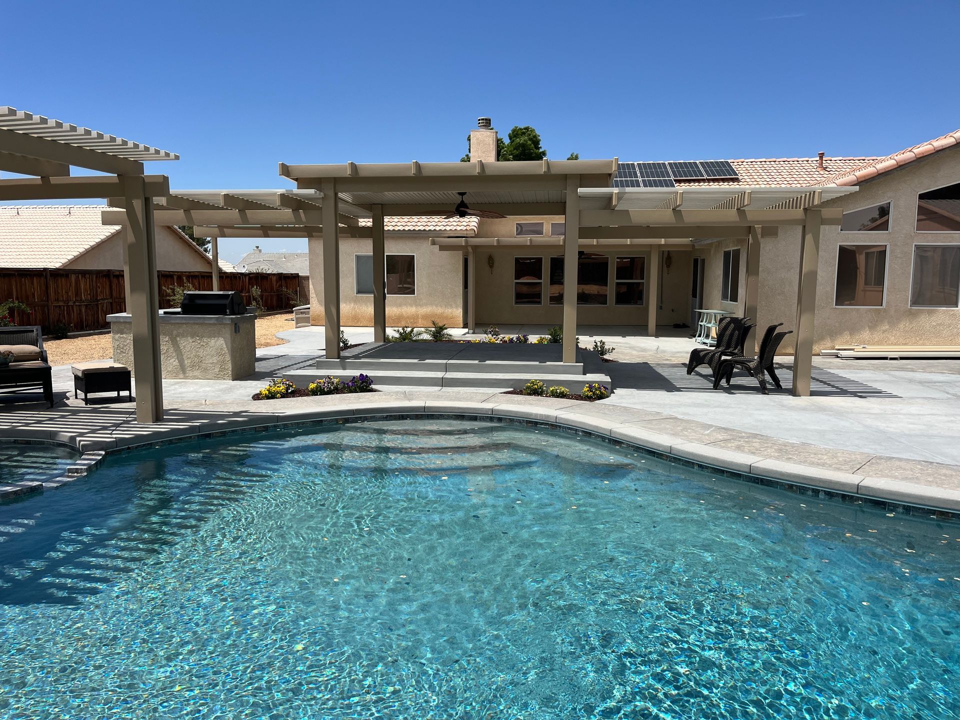 There is a large swimming pool in the backyard of a house.