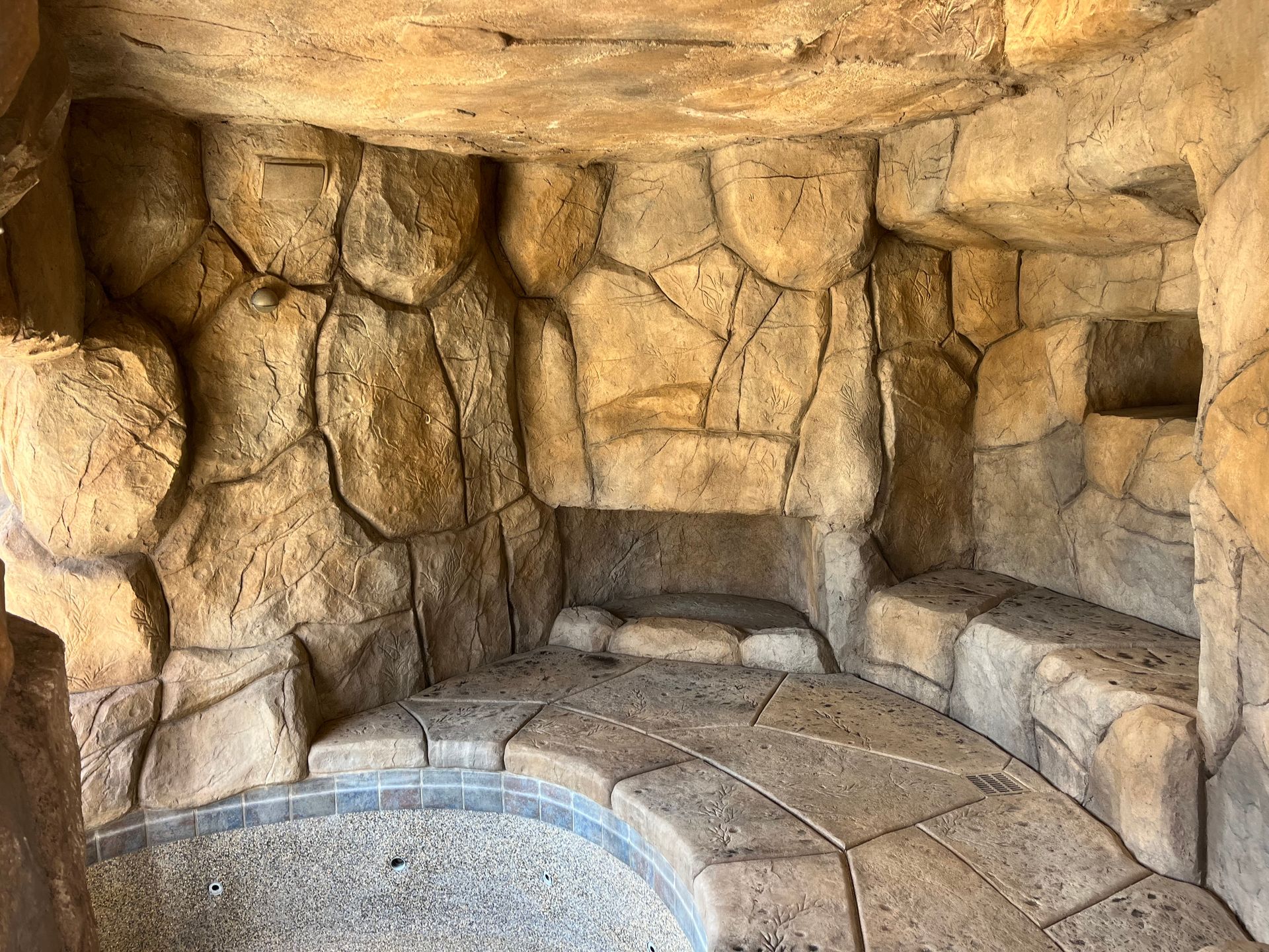 A cave filled with rocks and a pool in the middle.