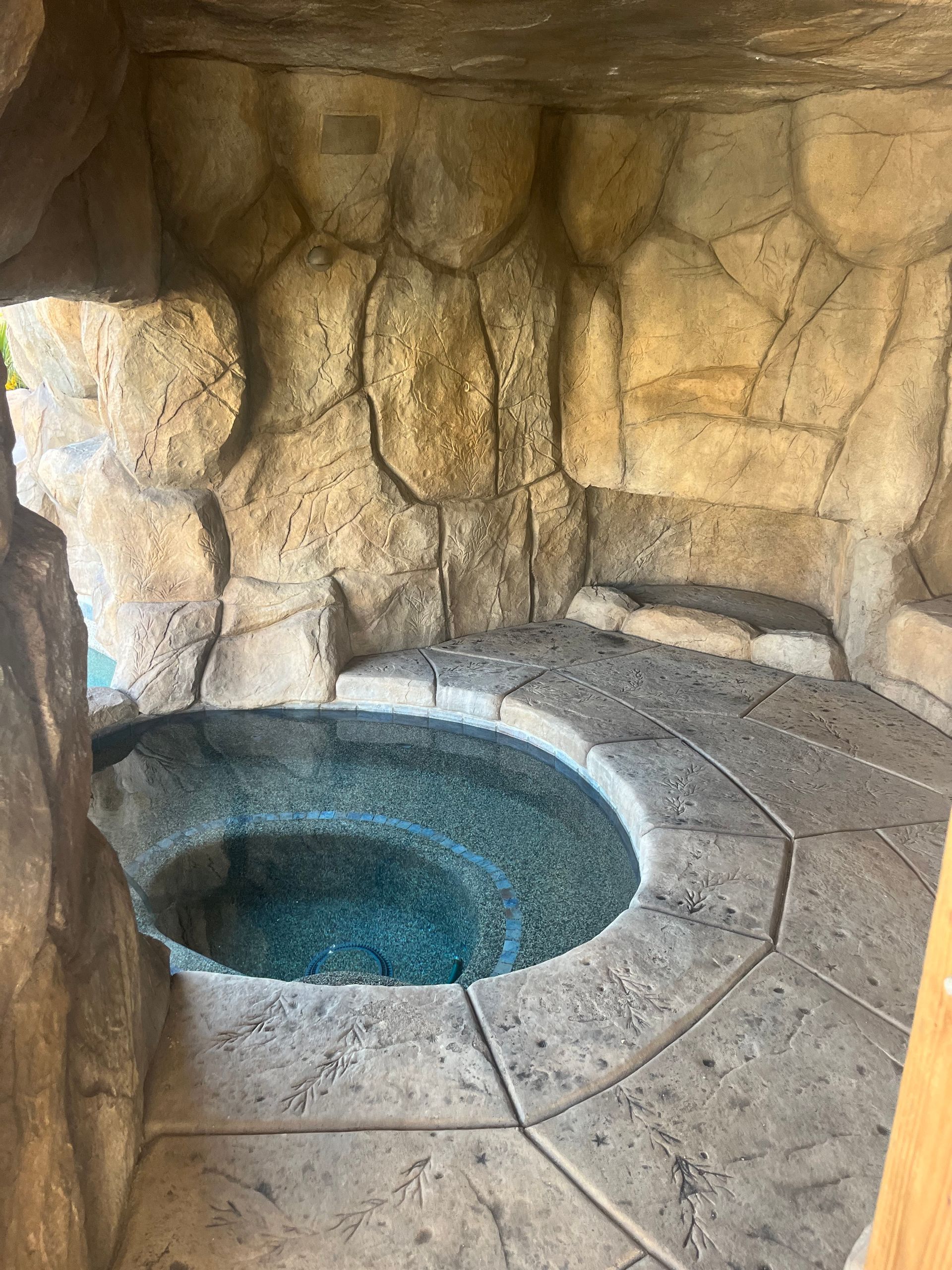A hot tub in a cave surrounded by rocks.