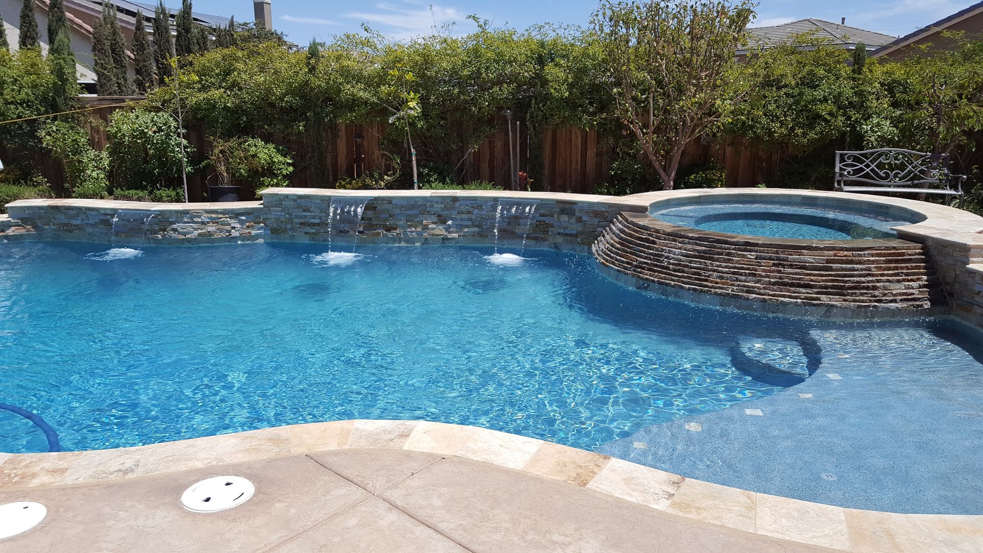 A large swimming pool with a hot tub in the middle