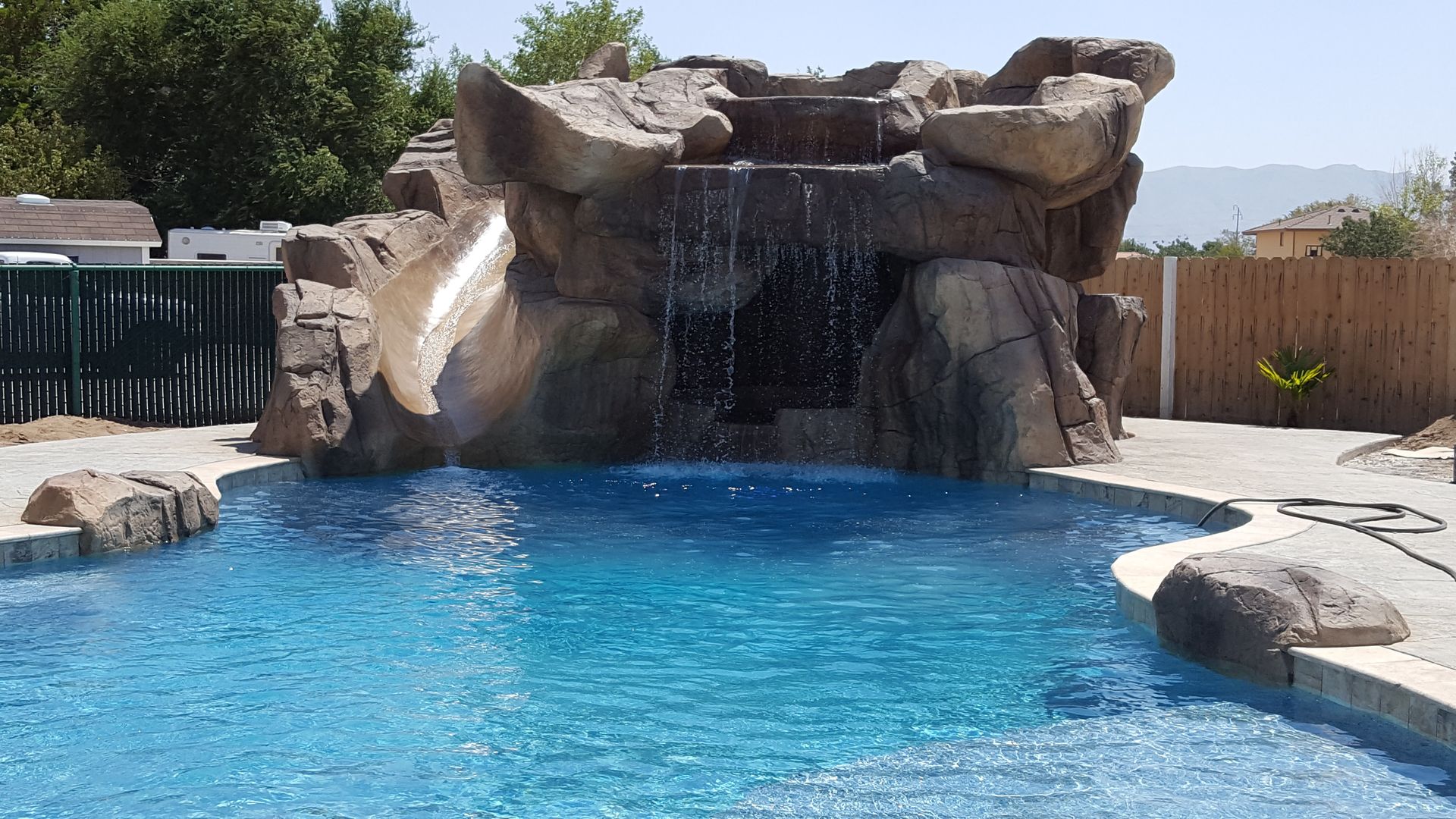 A large swimming pool with a waterfall in the middle