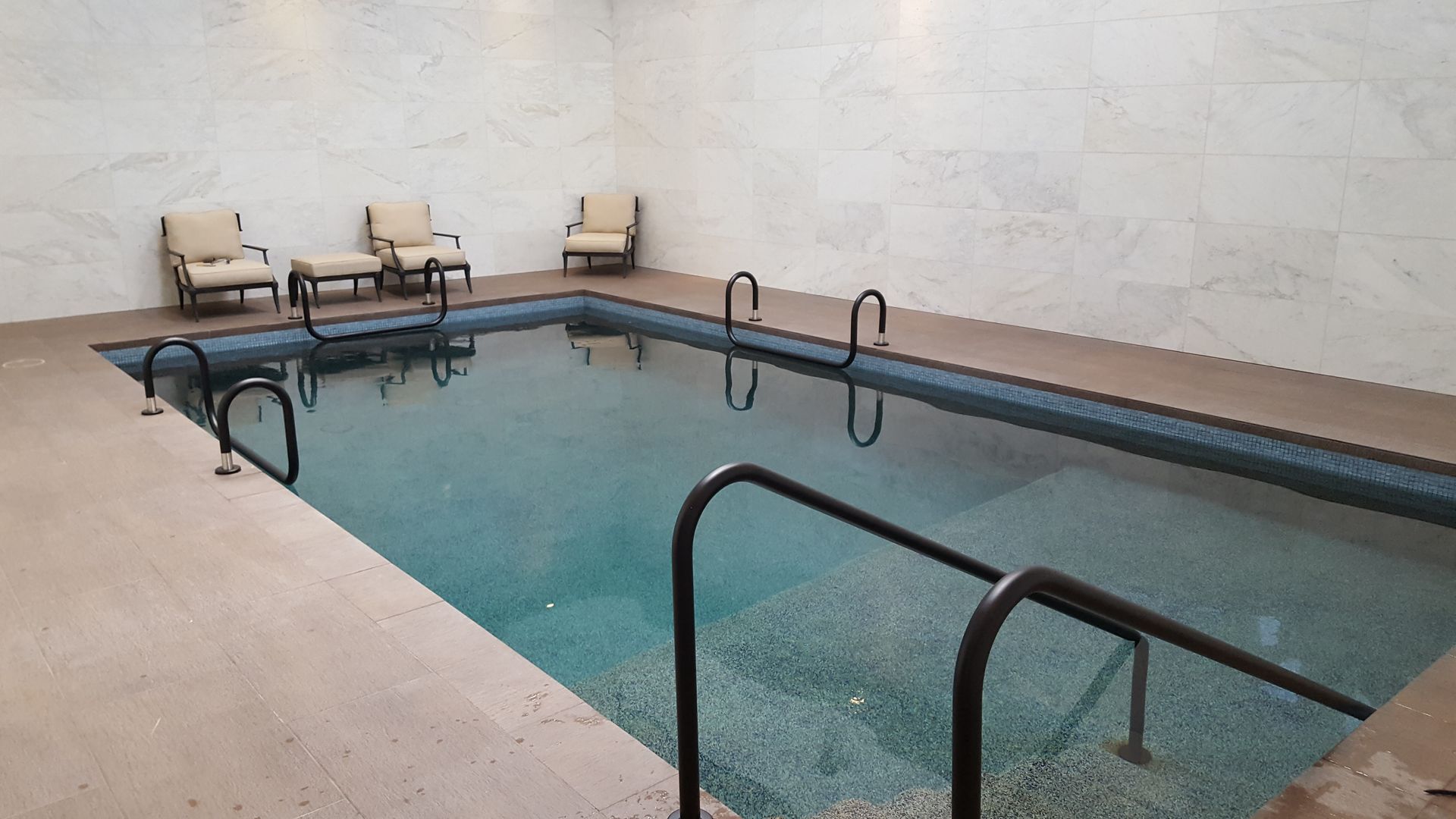 A large indoor swimming pool with chairs around it