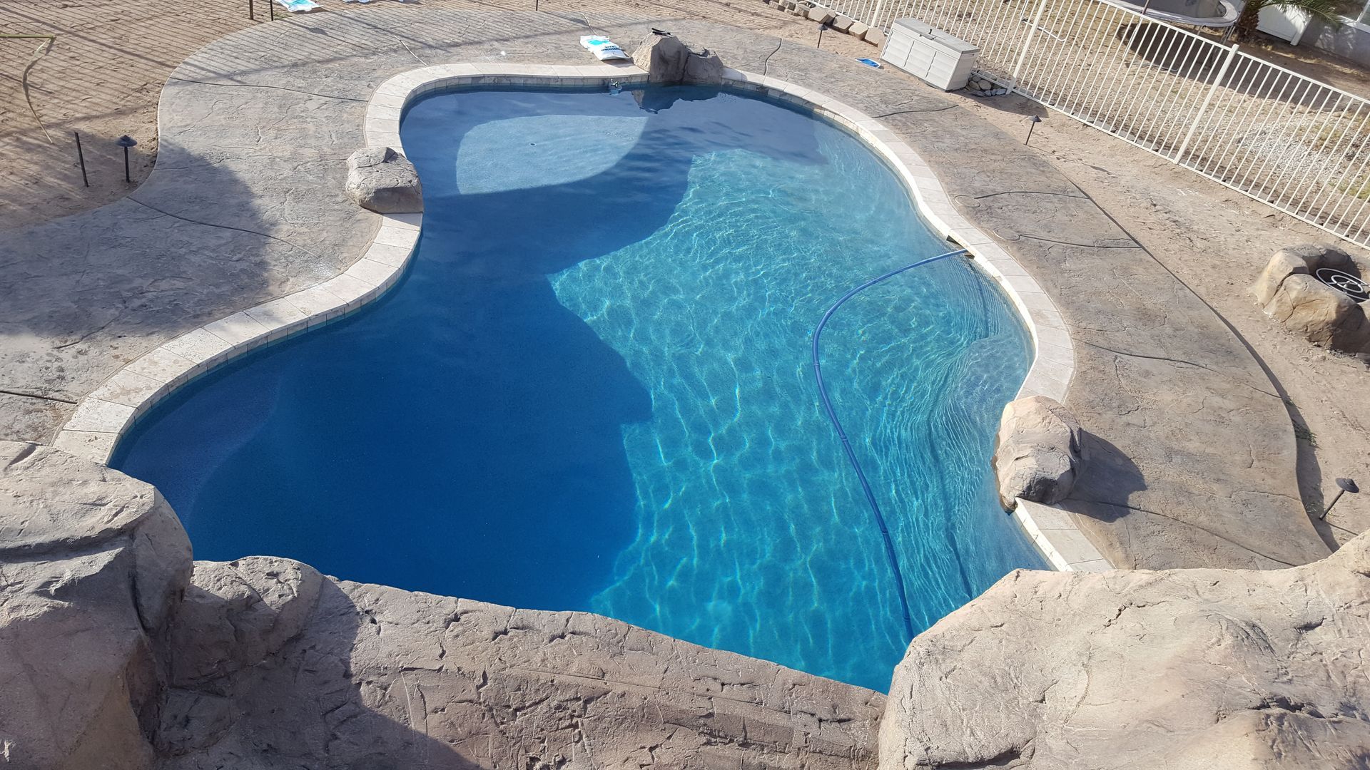 An aerial view of a large swimming pool surrounded by rocks.