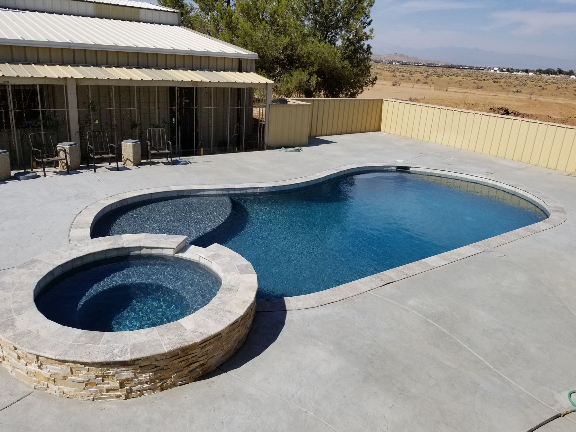 A large swimming pool with a hot tub next to it