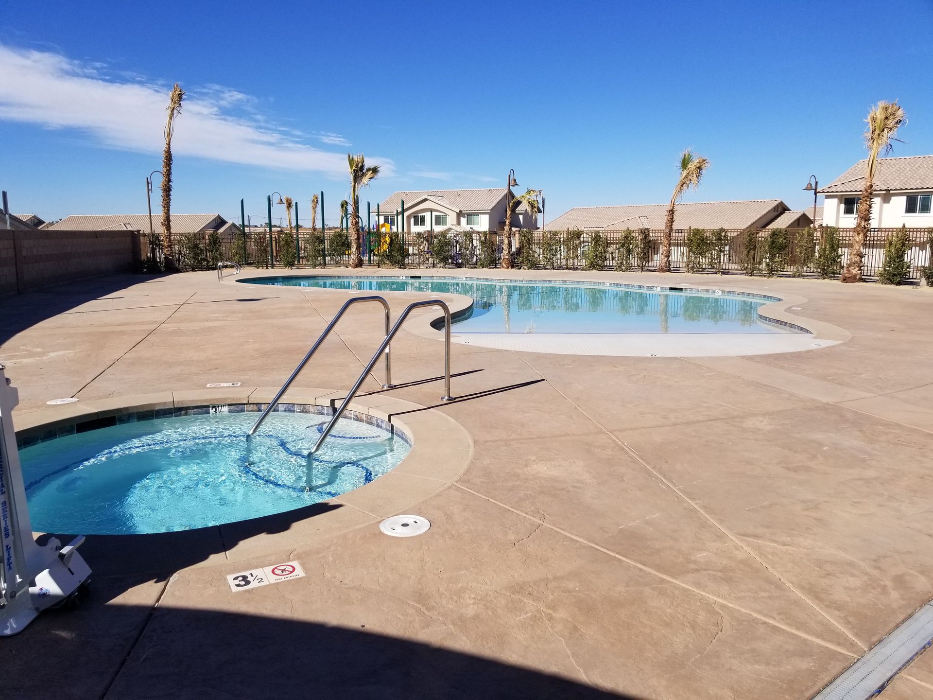 A large swimming pool with a hot tub in the middle