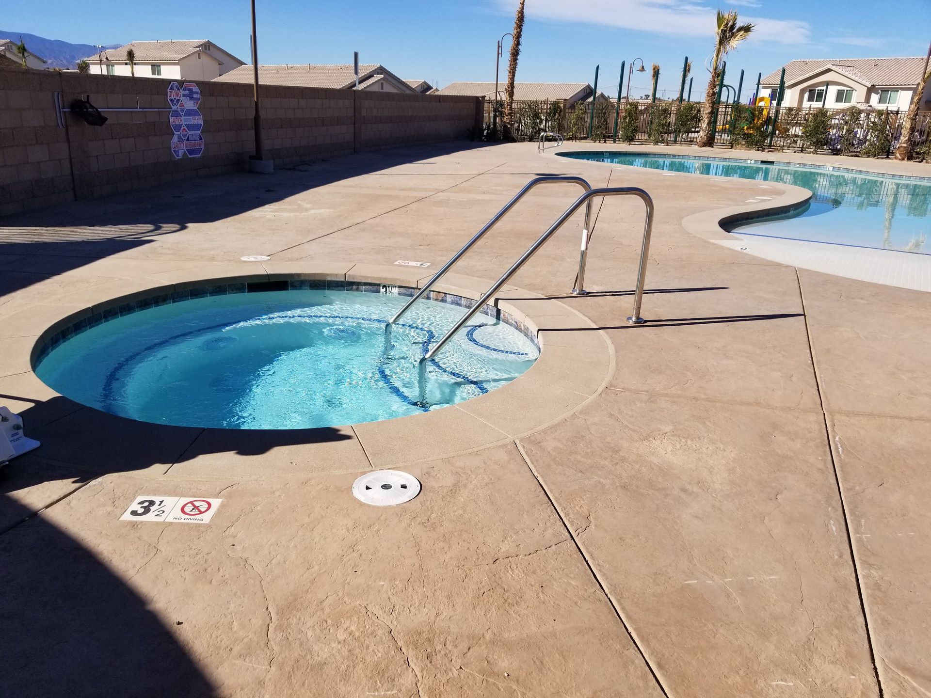 A swimming pool with a hot tub in the middle of it