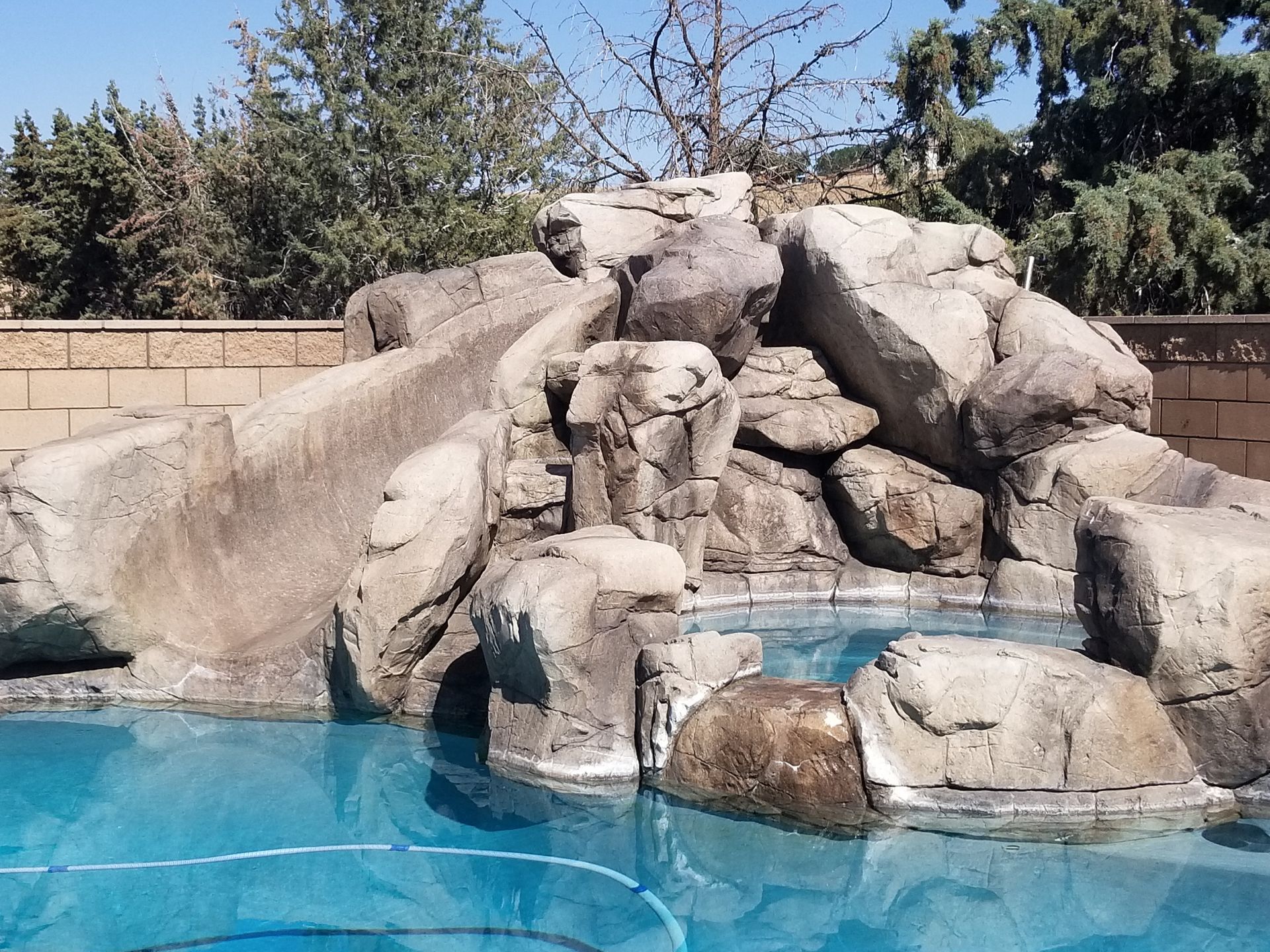 A swimming pool with a waterfall in the middle of it