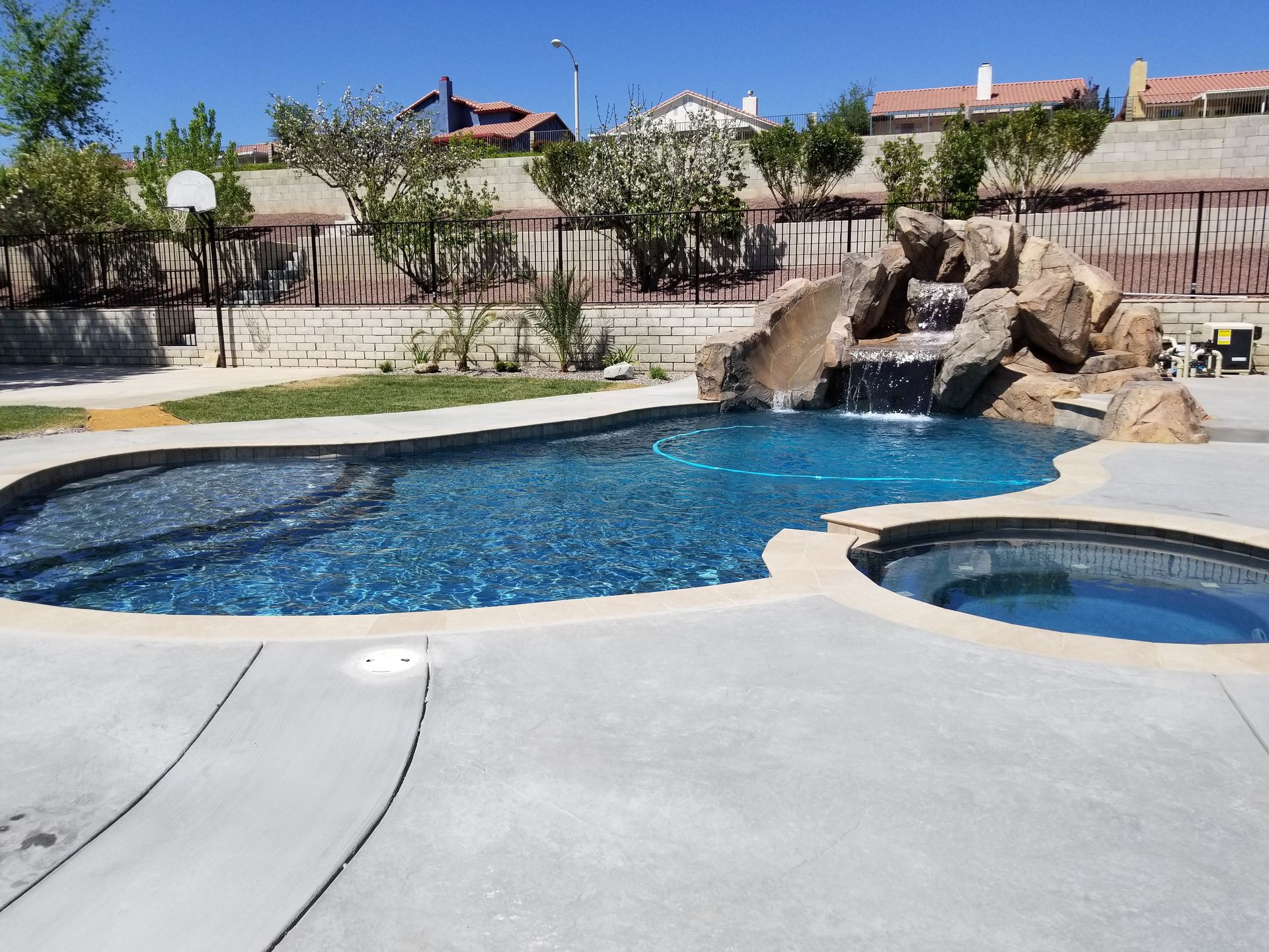 A large swimming pool with a water slide and a hot tub