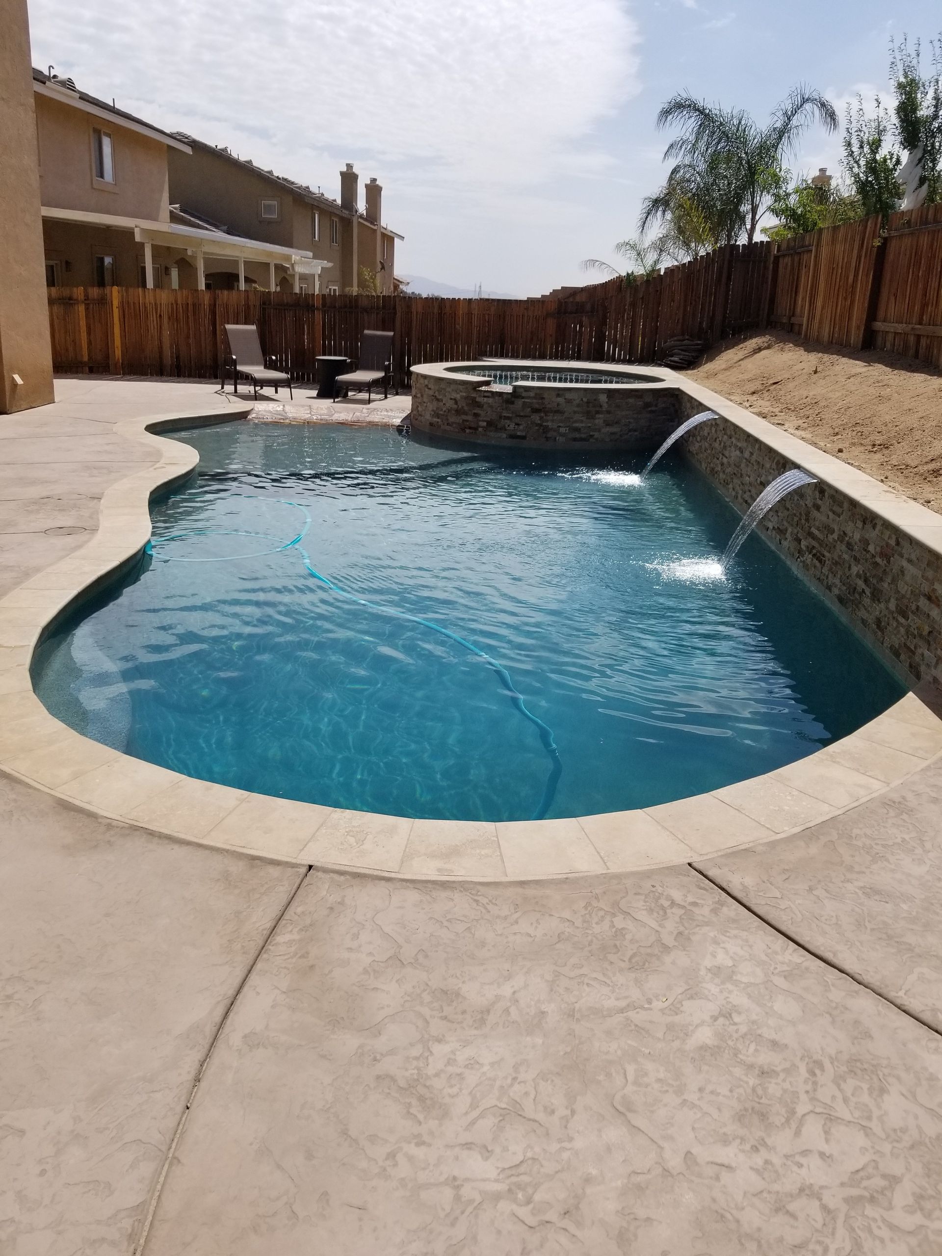 A large swimming pool with a waterfall in the middle