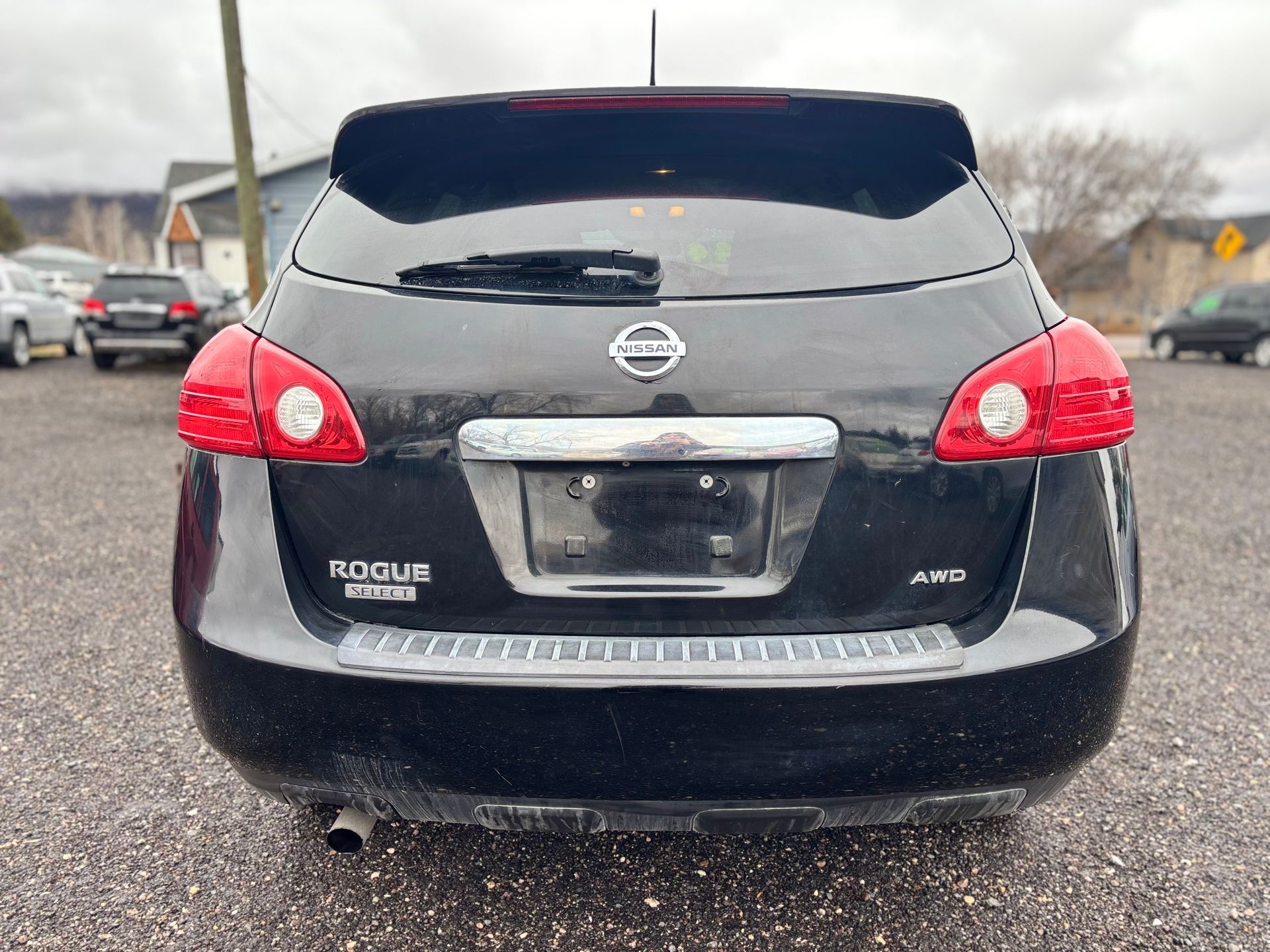 Black Nissan Rogue SUV rear view, with taillights, license plate, and chrome accents.