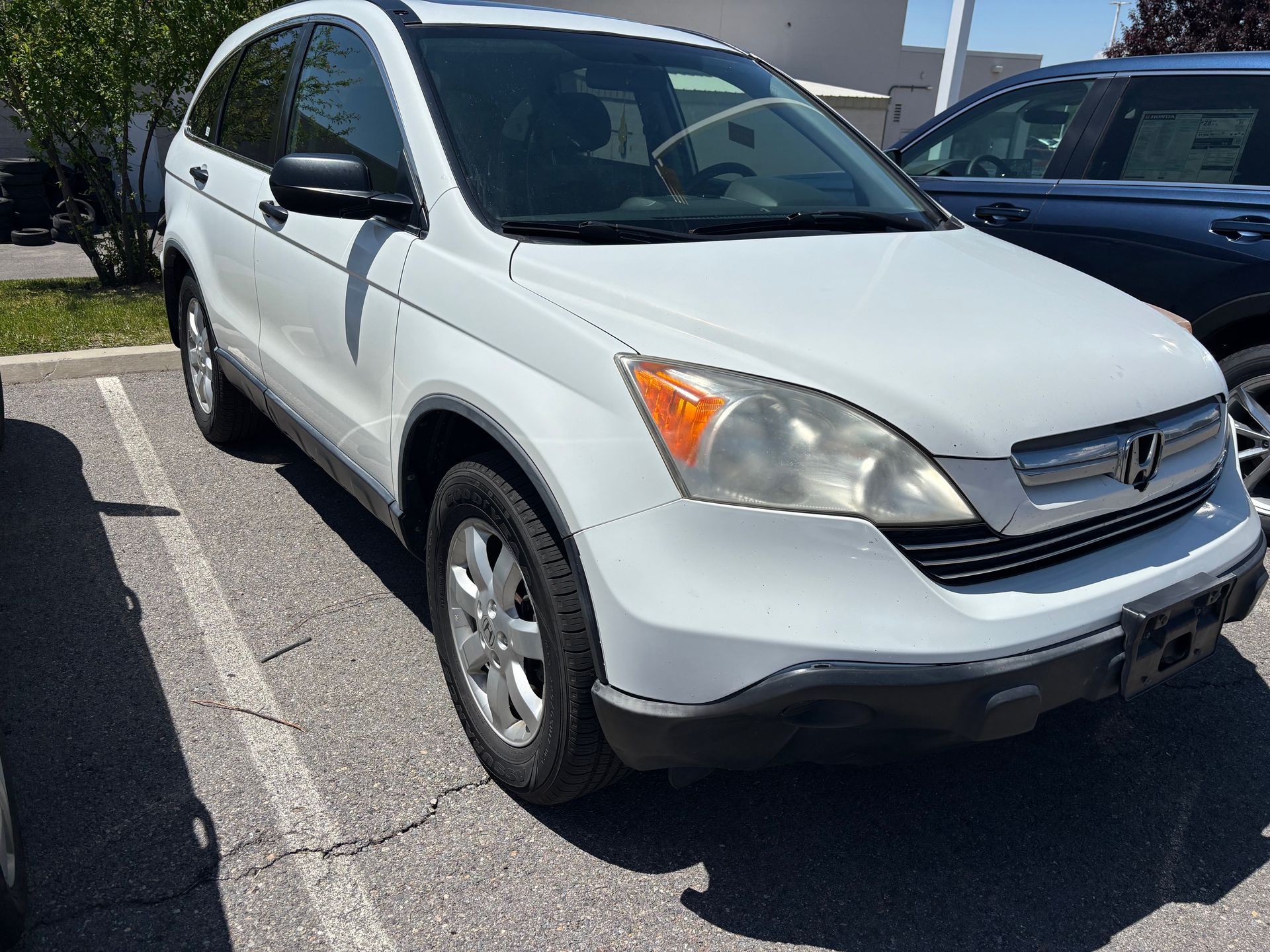 A white honda cr v is parked in a parking lot.