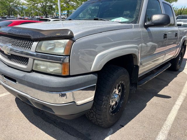 A silver pickup truck is parked in a parking lot.