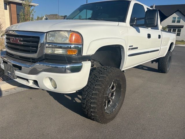 A white gmc truck is parked on the side of the road.