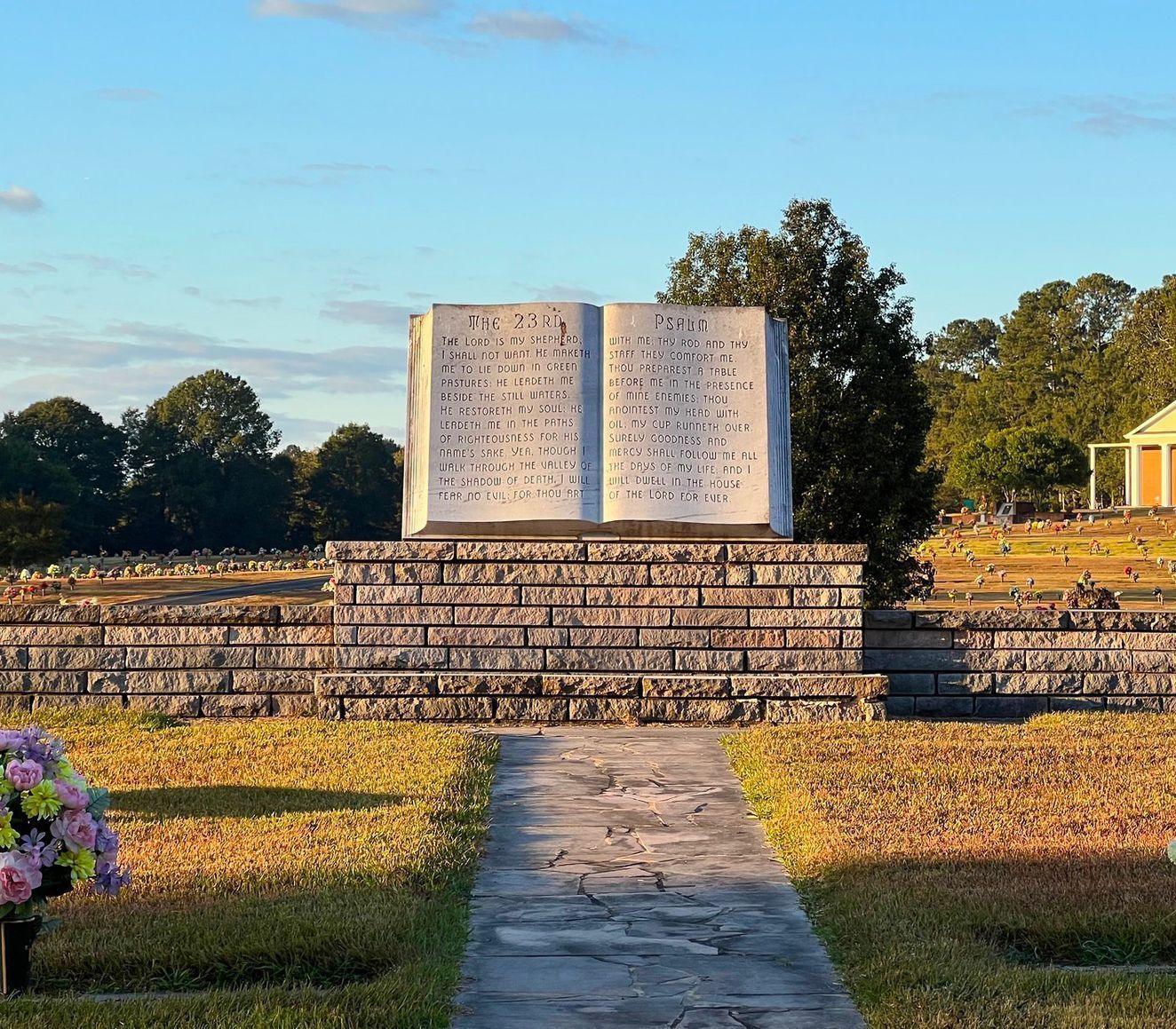 A graveyard with a statue of an open book in the middle