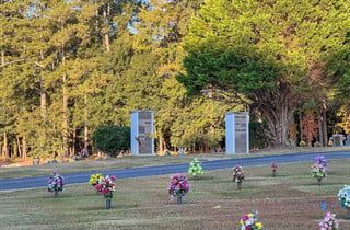 A cemetery filled with lots of flowers and trees.