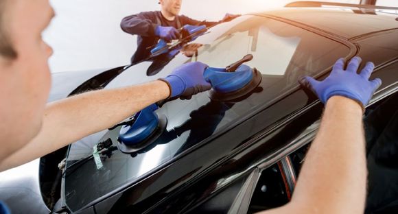 experts installing windscreen if a car