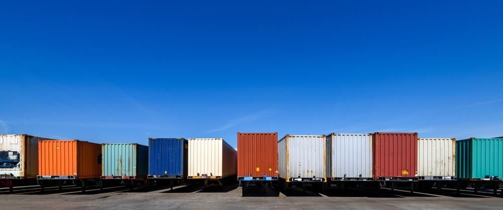 A Row of Shipping Containers Are Lined up In a Parking Lot — Alfie's Towing In Bentley Park, QLD