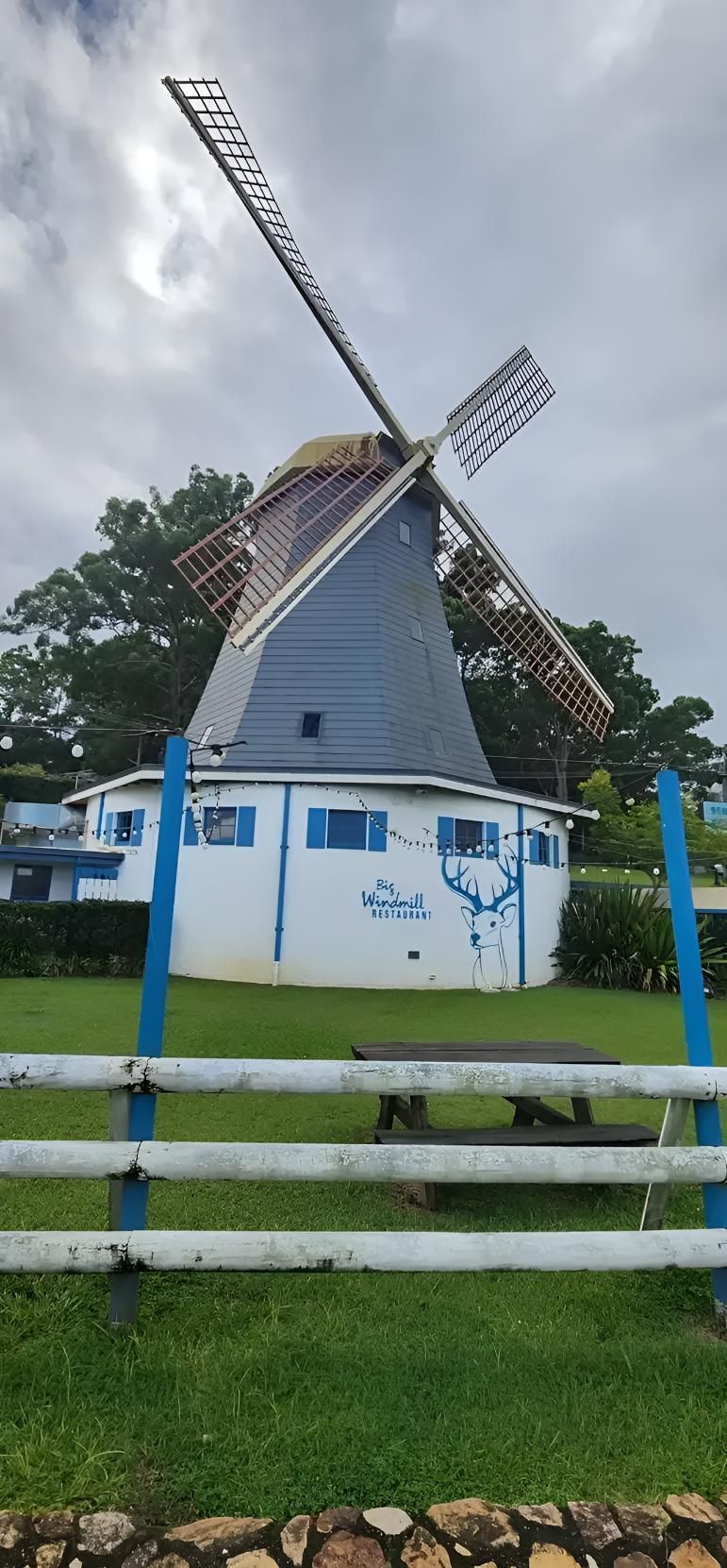 A Large Windmill is Behind a Blue and White Fence — Coastal Test & Tag in Bonville. NSW