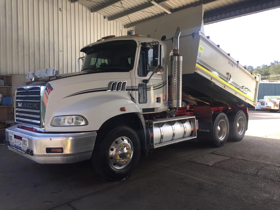 A White Mack Dump Truck Parked in a Warehouse — Mid North Coast Heavy Vehicle Repairs In Laurieton, NSW