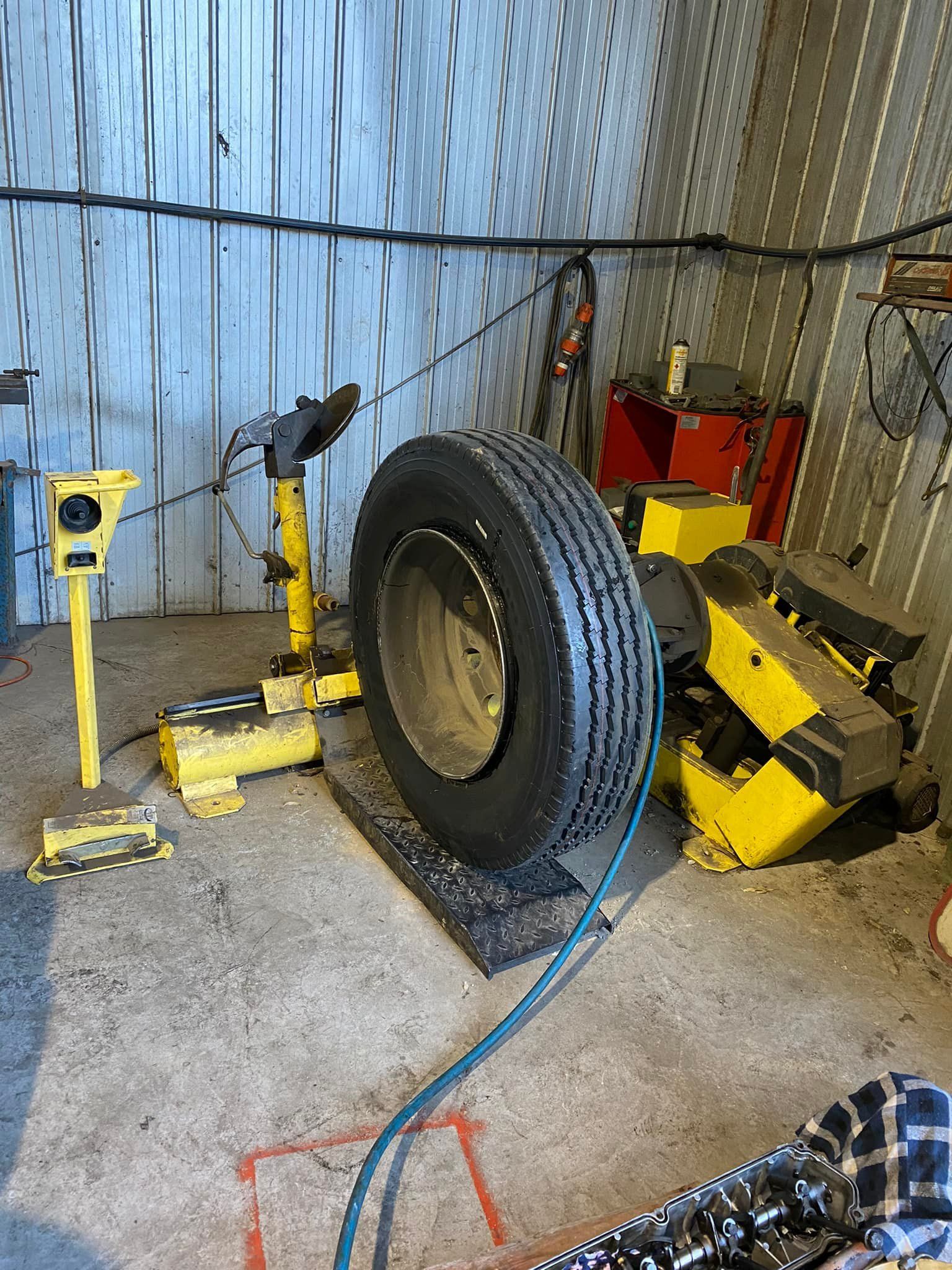 A Large, Mounted Truck Tire Sits on a Shop Floor — Mid North Coast Heavy Vehicle Repairs In Wauchope, NSW