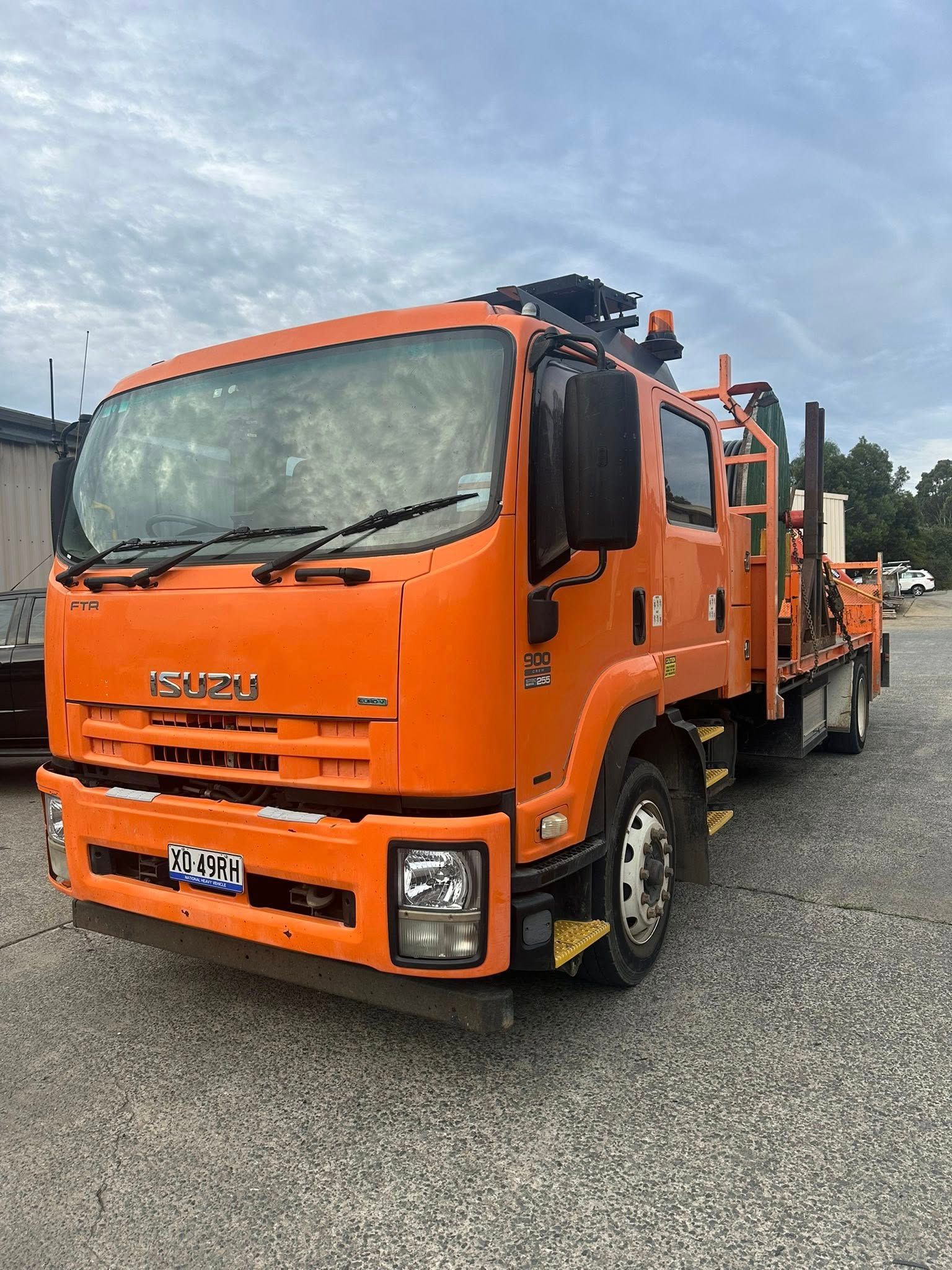 An Orange Isuzu Service Truck Parked on a Gravel Lot — Mid North Coast Heavy Vehicle Repairs In Port Macquarie, NSW