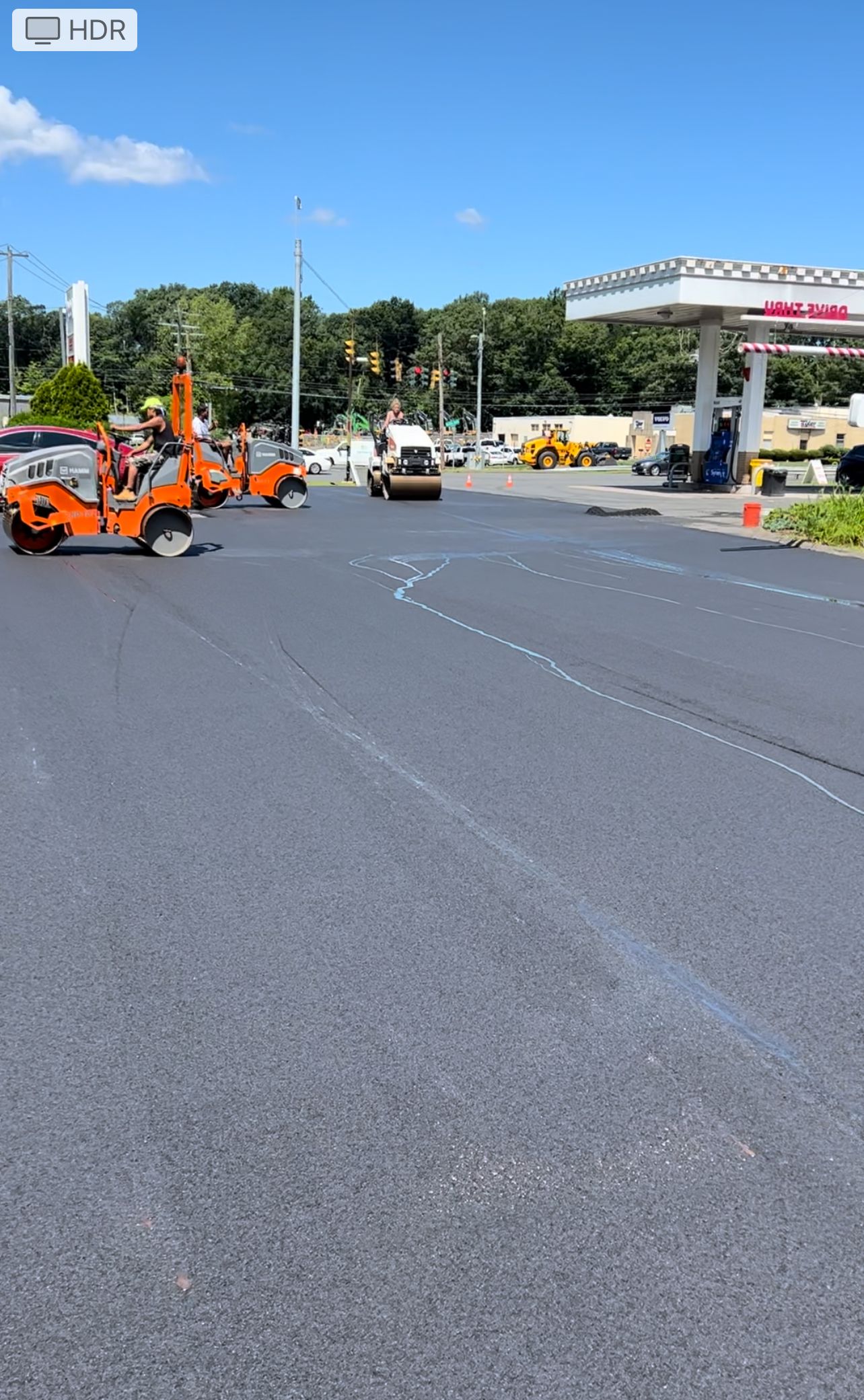 A parking lot with a gas station in the background