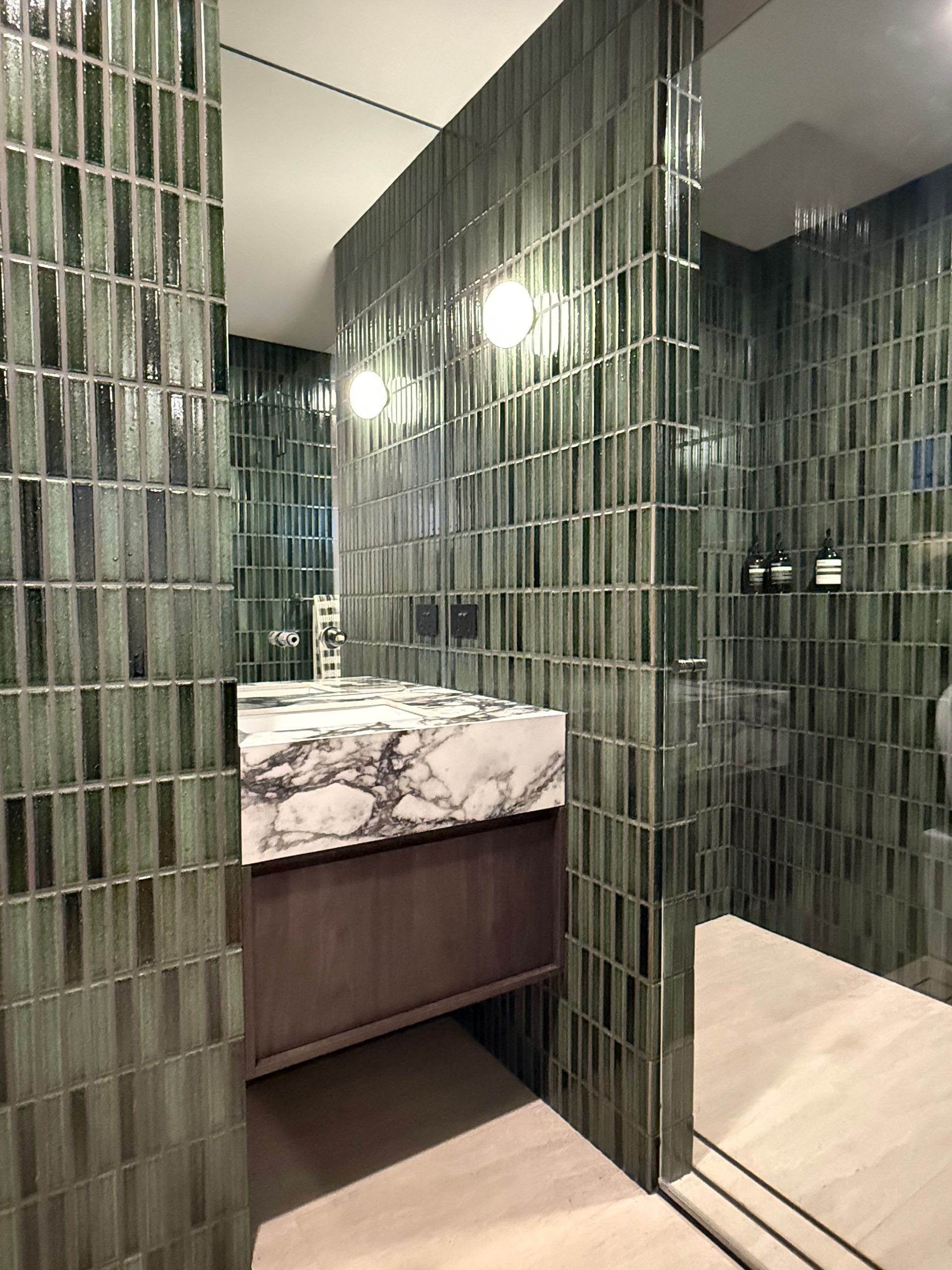 Green tiled bathroom with marble countertop and wooden cabinet — Canelo Cabinetry In Rocklea, QLD