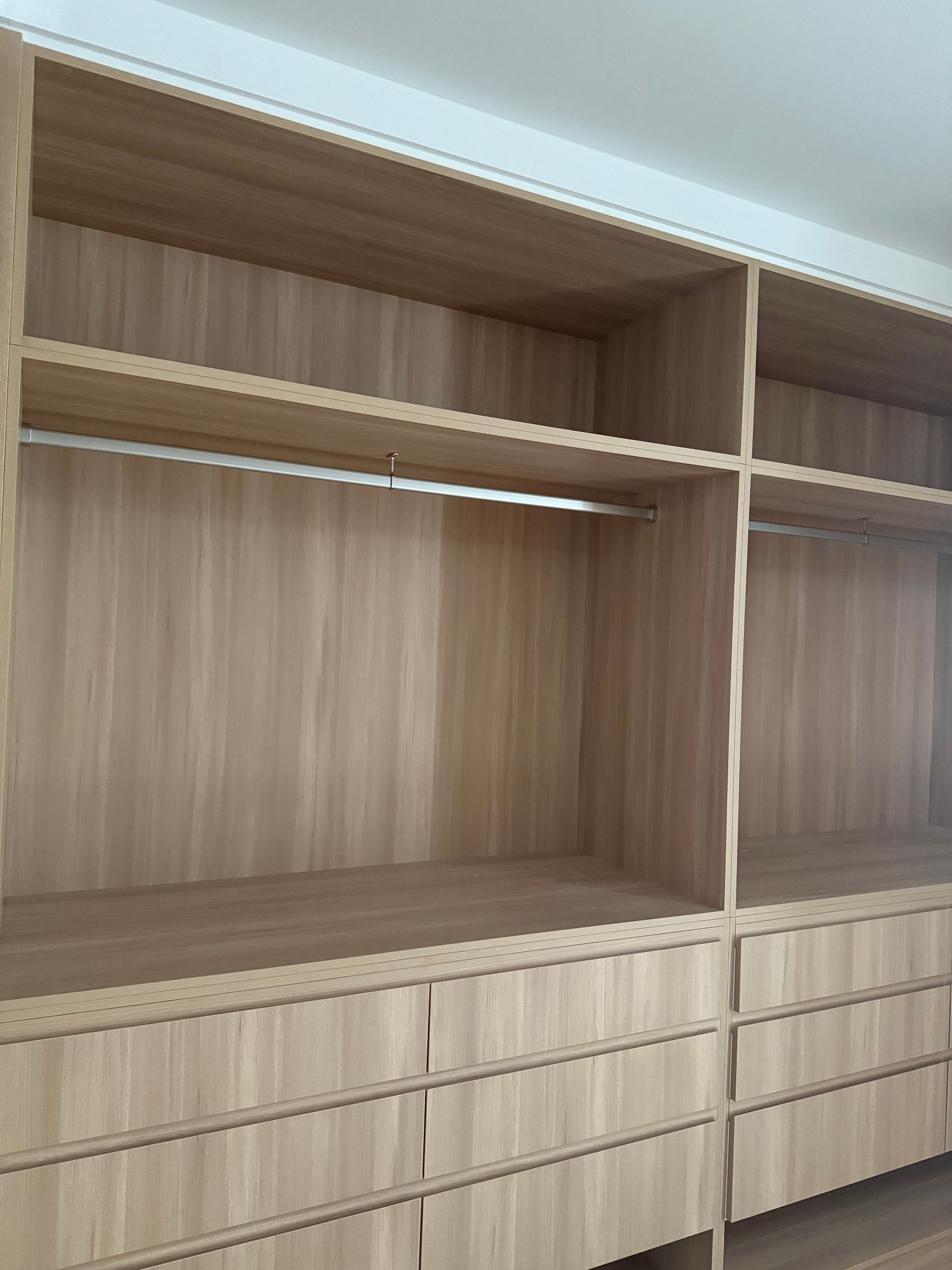 Built-in wooden closet with shelves, drawers, and hanging rods. Natural wood finish, light tan color — Canelo Cabinetry In Rocklea, QLD