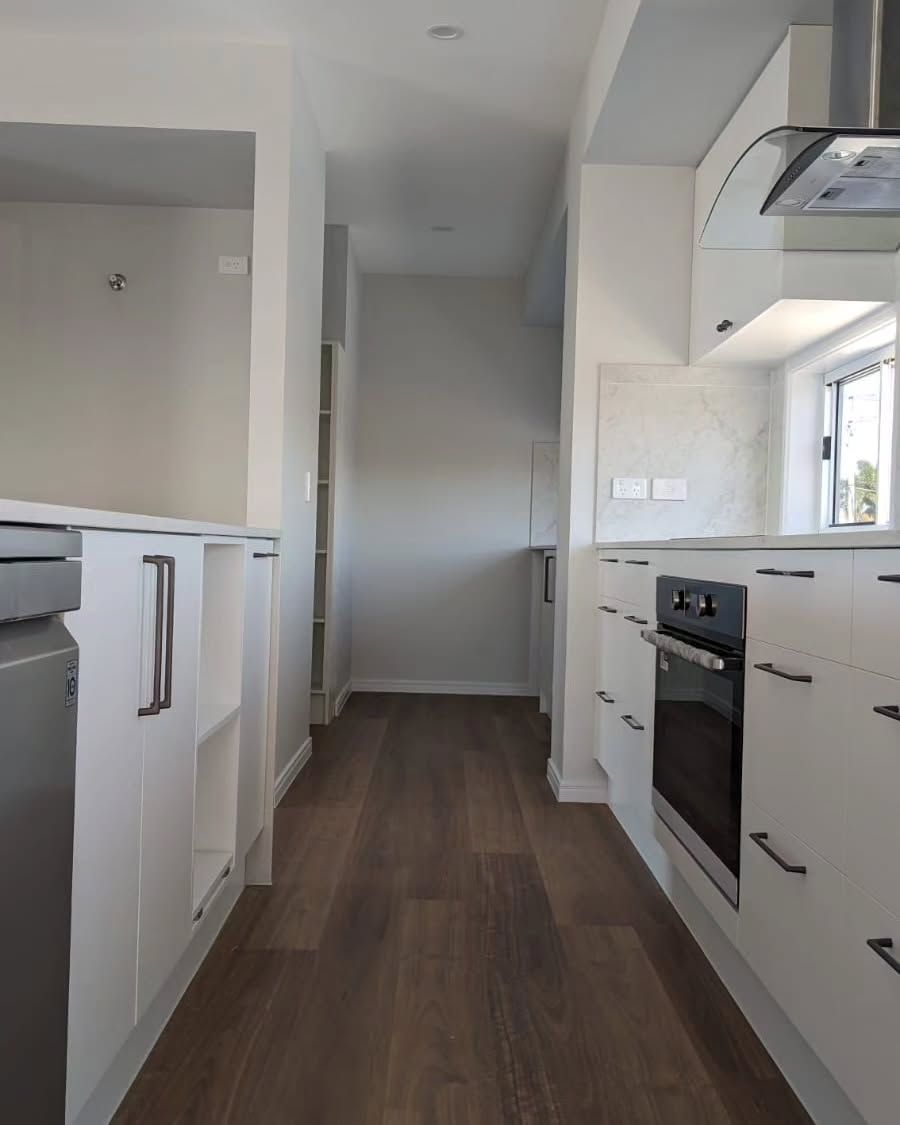 Narrow White Kitchen With Dark Wood Floors — Canelo Cabinetry In Rocklea, QLD
