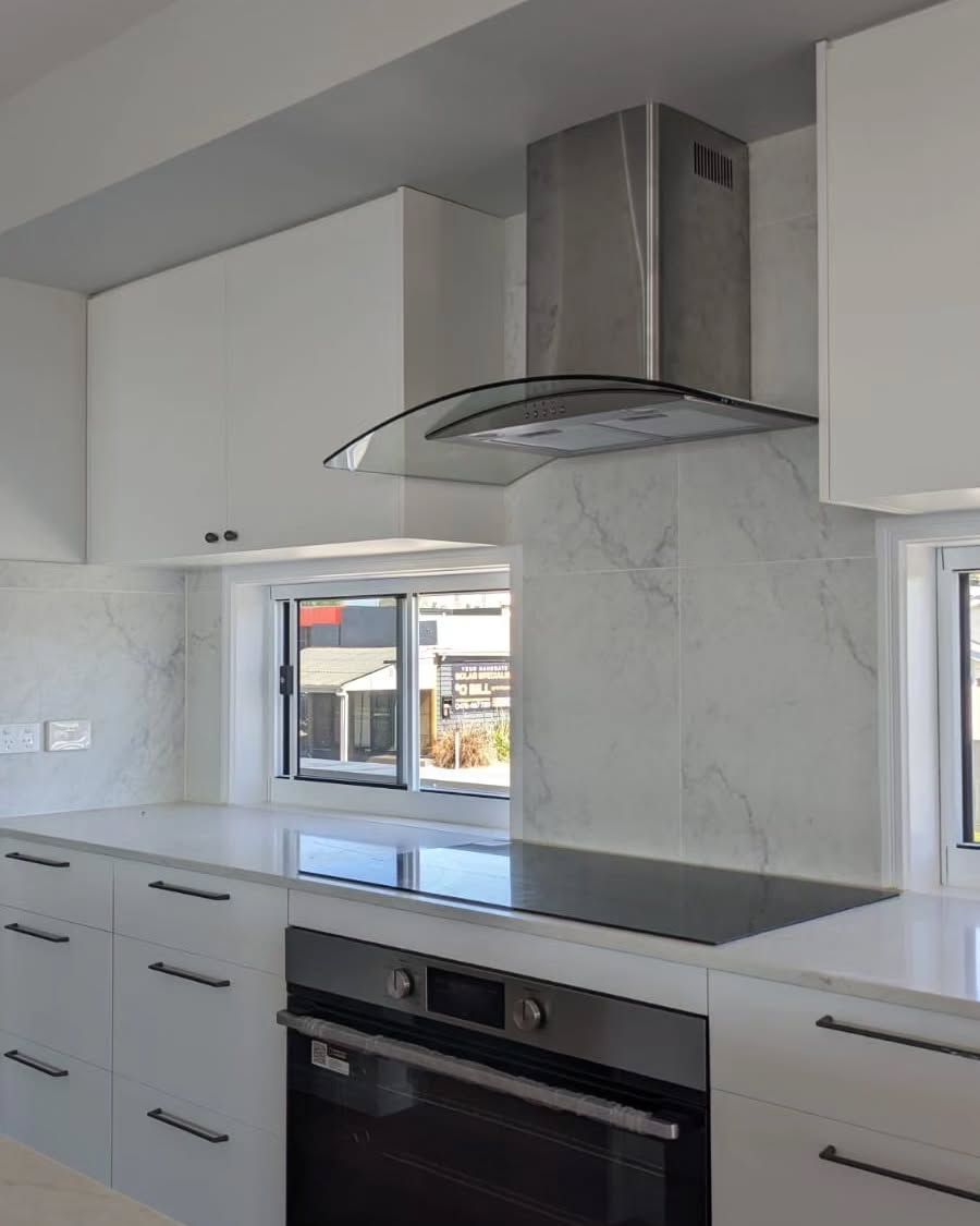 Modern White Kitchen With Stainless Steel Range Hood, Oven, and Marble Backsplash — Canelo Cabinetry In Rocklea, QLD