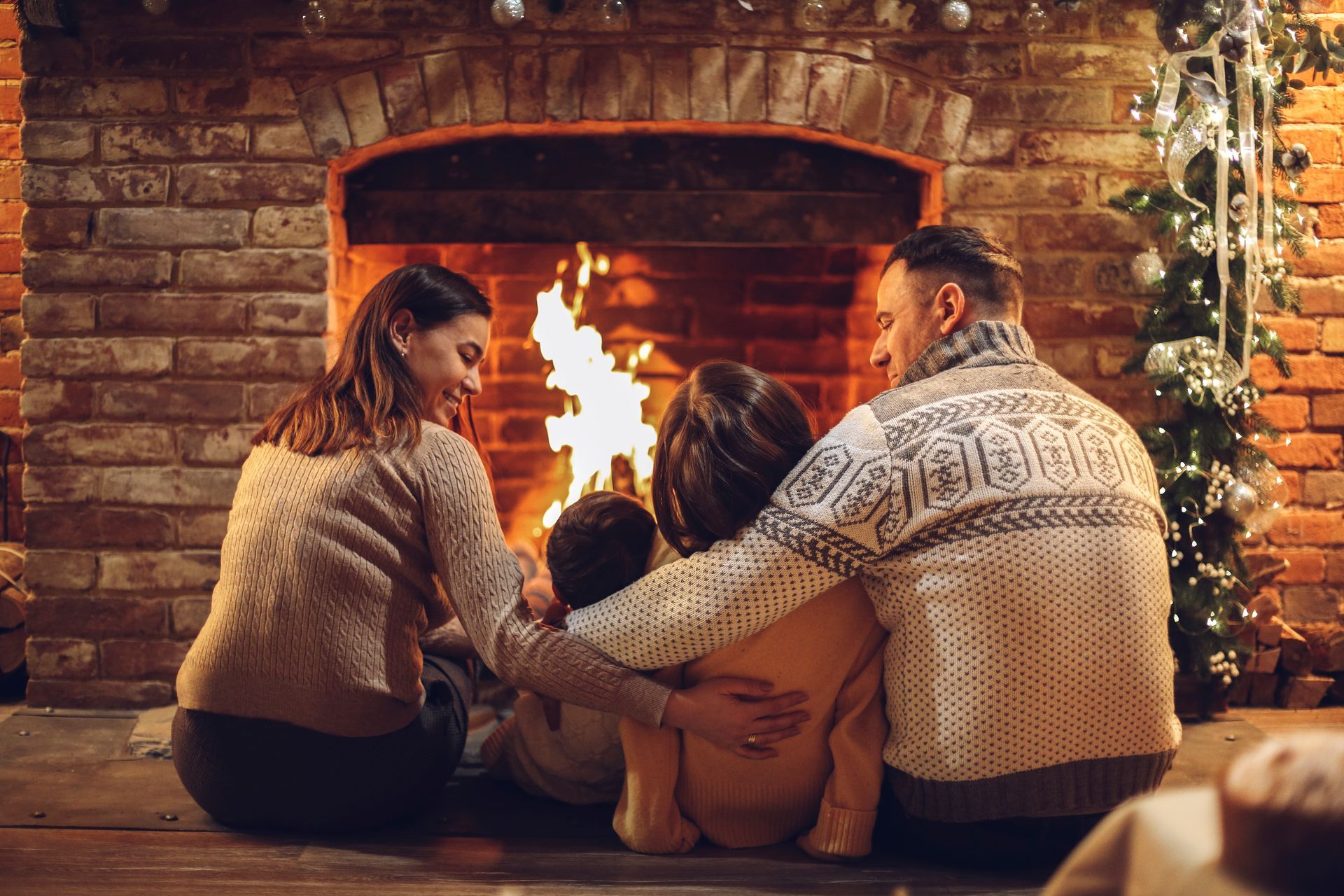 Family snuggled together in front of a fireplace, enjoying the warmth.