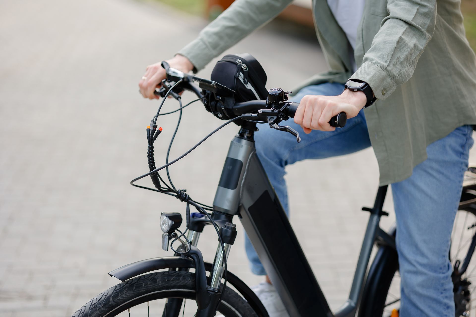 Person riding a black electric bicycle on a paved path.