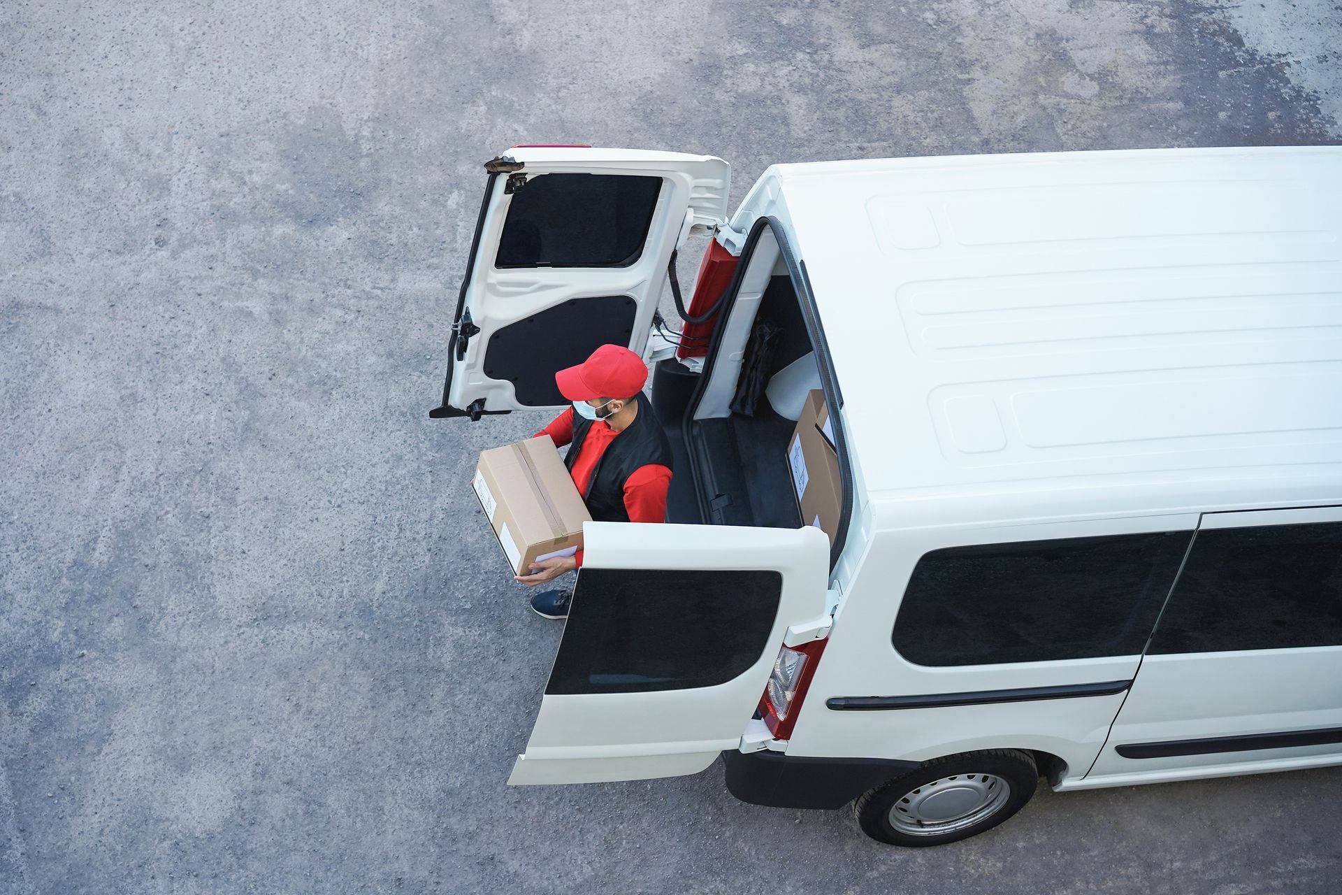 Grandparents and child loading items into a car trunk outside a building.