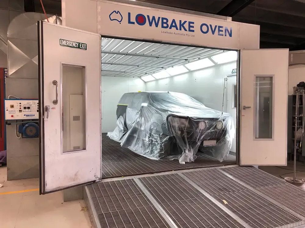 A Car Is Being Painted In A Lowbake Oven — Atherton Smash Repair Specialist in Atherton, QLD