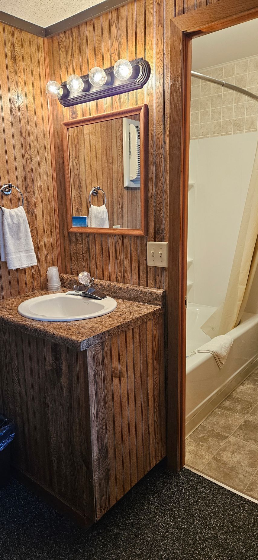A bathroom with a sink , mirror and tub.