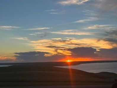 The sun is setting over a body of water.