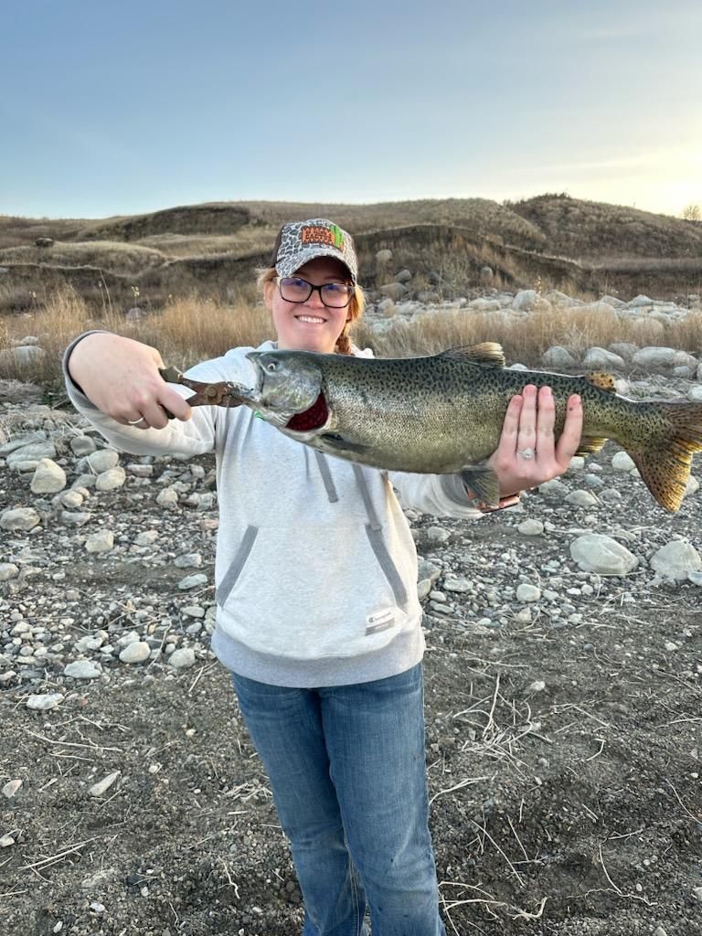 A woman is holding a large fish in her hands.