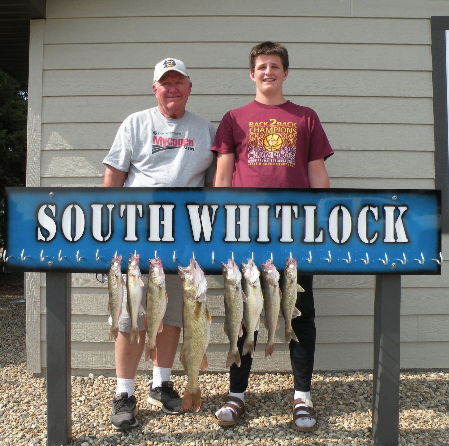 Two men standing under a sign that says south whitlock