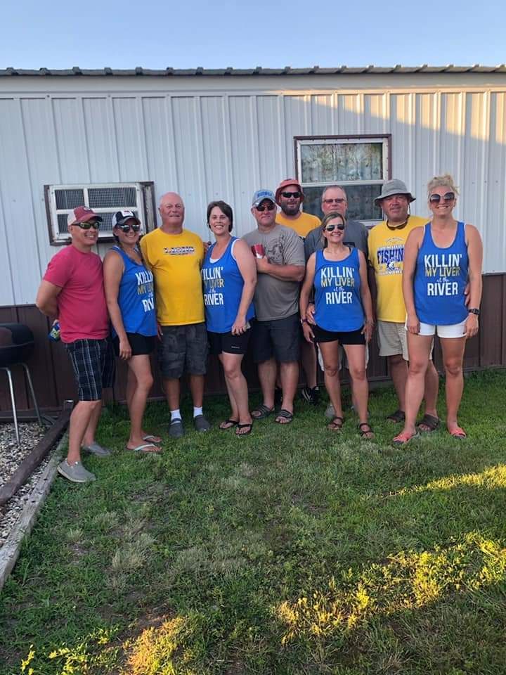 A group of people are posing for a picture in front of a house.