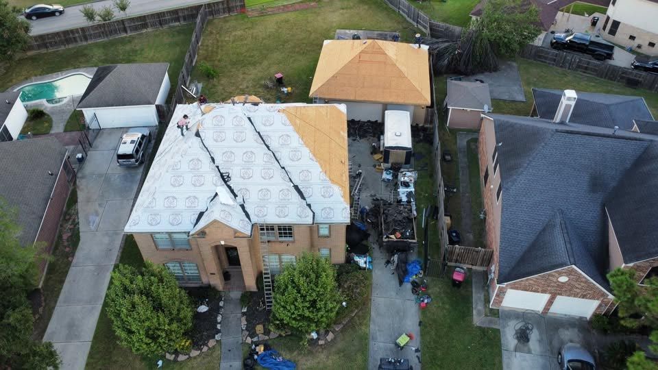 An aerial view of a house with a new roof being installed.