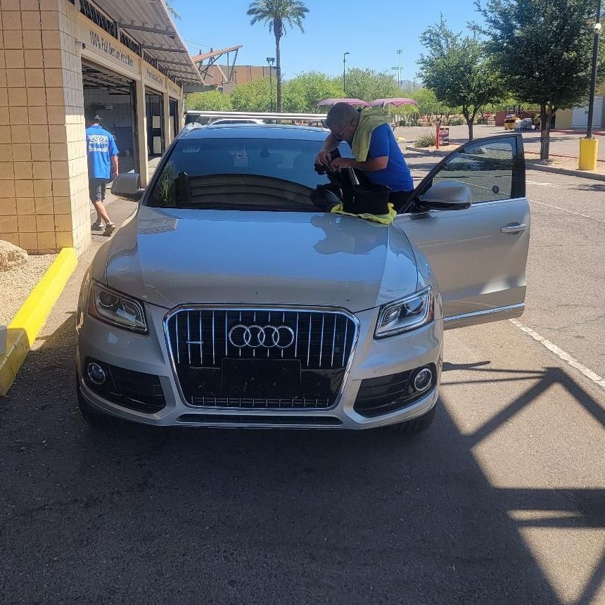 A family is playing with a soccer ball in a field.