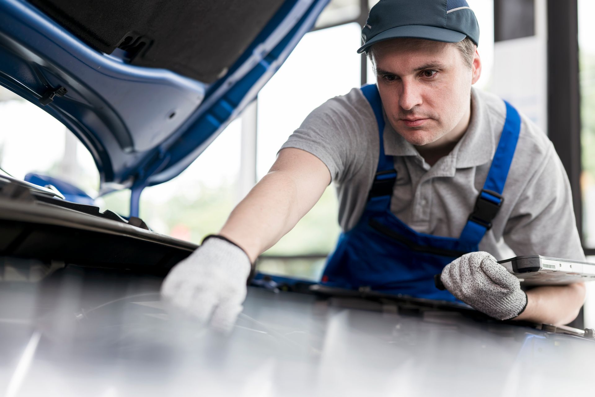 Expert mechanic conducting thorough maintenance under a vehicle Expert mechanic conducting thorough maintenance under a vehicle