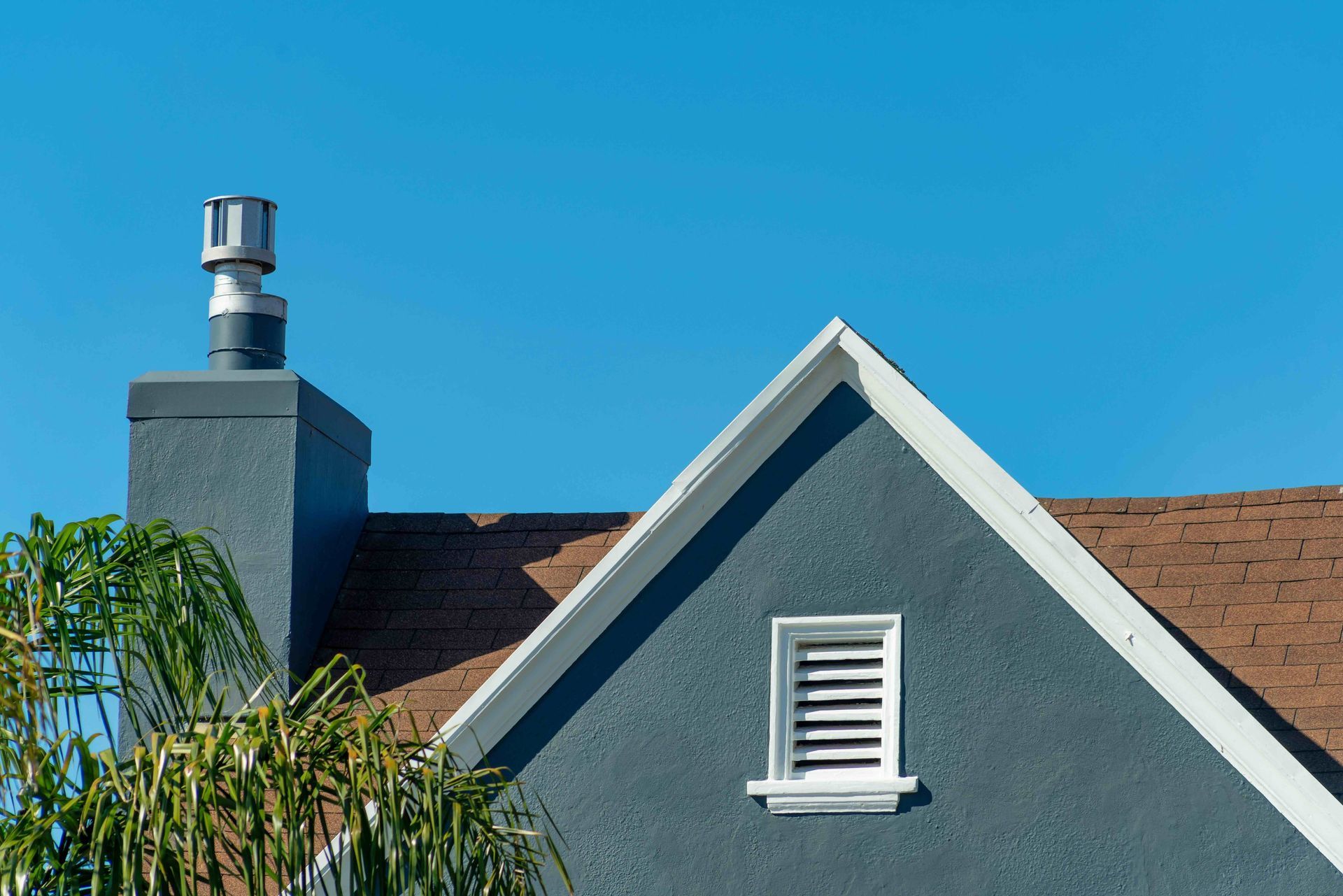 the roof of a house with a chimney and a window .