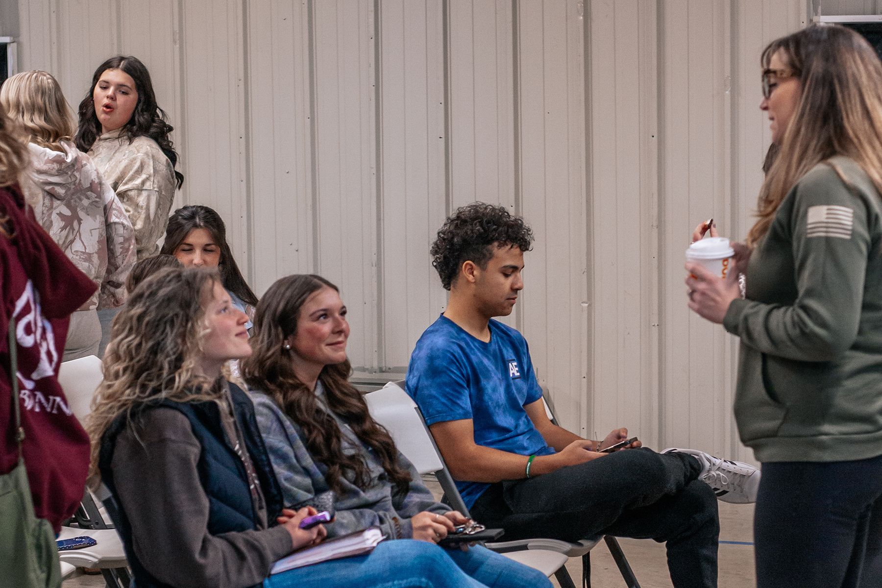 A woman is smiling while sitting at a table with a book.