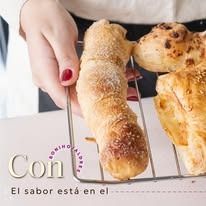 Una persona sostiene una rejilla de productos horneados, incluido pan, con las palabras