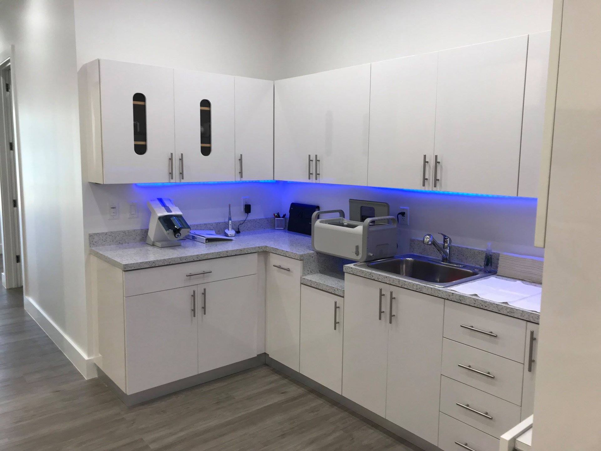 A kitchen with white cabinets and a sink.